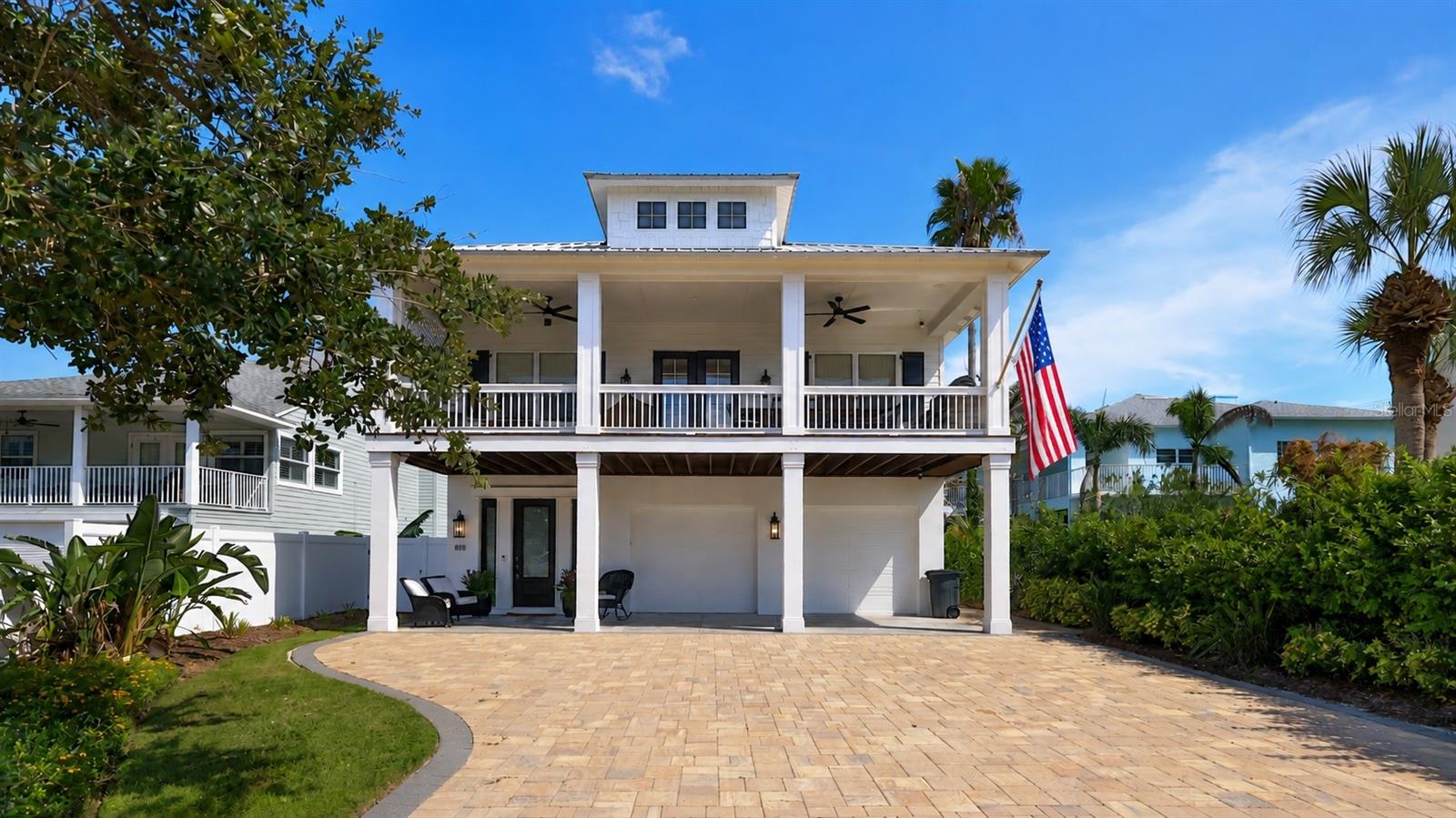 SHORT-TERM RENTAL ZONE — TURNKEY & JUST STEPS TO THE BEACH! This immaculate, custom Hickson-built 4-bedroom, 4-bath coastal home offers the rare combination of luxury, location, and income potential. Built in 2016 and offered  it is ready to enjoy or put to work from day one.Designed in a timeless Southern coastal style, the two-story home is loaded with custom details including soaring tongue-and-groove vaulted ceilings, engineered wood flooring, an elevator, repurposed vintage doors, custom window treatments, and quartzite, granite, and marble surfaces throughout. The beautifully appointed primary suite features a soaking tub and distinctive trough sink.Outdoor living is equally impressive with a spacious deck and summer kitchen, perfect for entertaining after a day at the beach. The home is equipped with natural gas, two tankless water heaters, a gas fireplace, a new 26kW whole-house generator (October 2025), impact-rated double-pane windows, metal roof, security system with Google cameras and Nest, and two newer A/C systems installed May 2024. Washer and dryer setups on both levels add extra convenience for owners and guests.An oversized garage, generous guest parking, and attractive paver driveway and walkways complete the property. Best of all, you're STEPS from the beach and only six blocks from Flagler Avenue, putting restaurants, shopping, nightlife, and entertainment within an easy walk, bike ride, or golf cart trip.Designer furnishings are negotiable as part of the purchase and include a curated mix of vintage pieces and recognizable names including Tommy Bahama, Ethan Allen, Pottery Barn, and Bernhardt. Whether you're looking for a beachside retreat, second home, or established vacation-rental opportunity, this one checks the boxes —