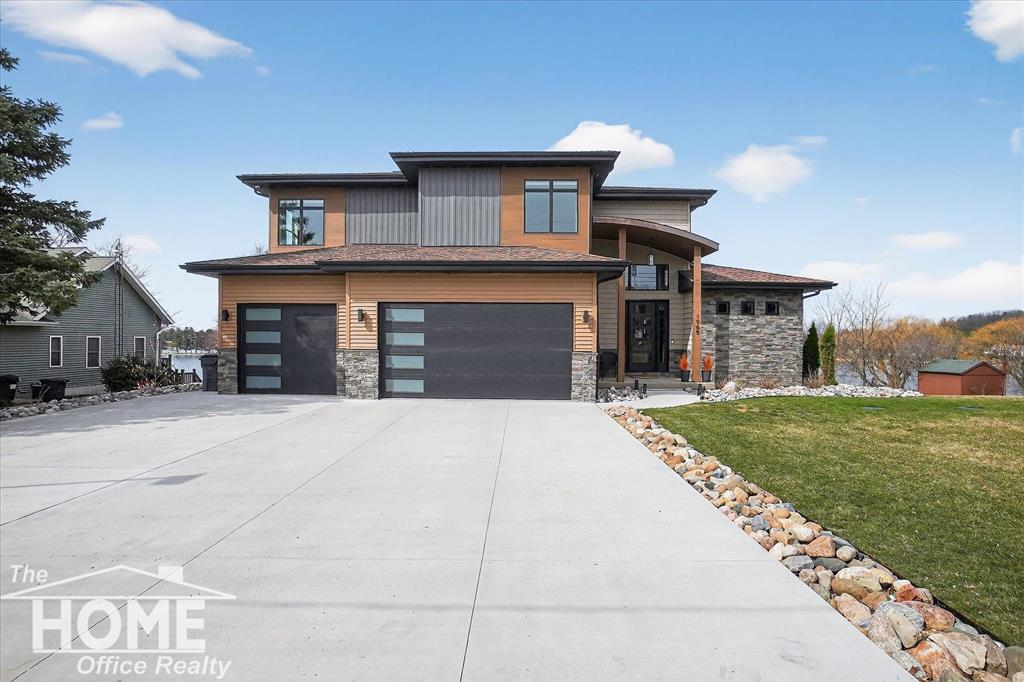 Luxury Lakefront Home on Private All-Sports Lake Manitou!  Built 2022 on a prime lot with 5 bedrooms, 4.5 baths, and 3 car heated garage, plus walkout lower level and theater room for a total of 6,945 finished square ft.  20 ft. ceilings welcome you into the living room with wall of windows overlooking the lake and open to a cook's dream kitchen perfect for entertaining with quartz counters and backsplash, high-end appliances, 2 pot fillers, Pioneer cabinetry, coffee/beverage bar area, and walk-in butler's pantry. 16 ft. sliders open to an expansive deck where one can relax and enjoy the view of the lake. Main level office with view of the lake makes work a pleasure.  Main level primary bedroom suite with one of four fireplaces and ensuite bath featuring quartz counters, walk-in shower with 6 sprayers and rain head shower, soaker tub, and walk-in closet with 2nd washer/dryer and steamer/sanitizer closet.  Upper level hosts a loft, 2 bedrooms with walk-in closets and a Jack n Jill bath, upper-level laundry, and a 2nd private bedroom suite with walk-in closet and ensuite bath. Lower level hosts a 5th bedroom, full bath, fitness room, and expansive great room with pool table, kitchen with island, and walkout to covered patio with hot tub and TV. Professionally landscaped stairs to the lake with lakeside patio, beach, and aluminum dock.  Lower-level theater room with 14 powered theater chairs and an 8K Ultra Throw projector with 9.1 surround sound system with HD player and concessions room for the ultimate movie experience.  3 car attached garage is heated with water and EV charging station.  Top quality construction with hand crafted details like the copper roof over the entry, and all the extra luxury living touches like robot vacuum system and air diffuser. Automatic whole house generator. Call for more details.