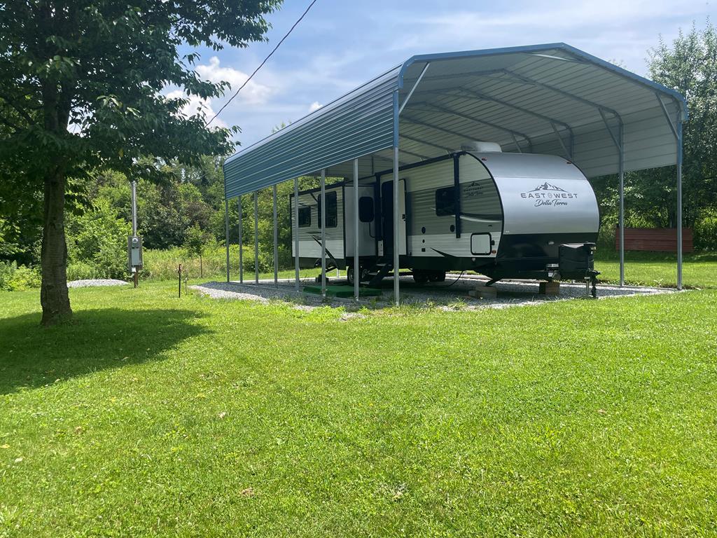 Are you looking for a weekend get away? This 2020 model East West Della Terra top of the line camper is located on 0.54 acre in scenic Sugar Grove, Va. It is located near the Jefferson National Forest, Virginia Creeper Trail, Hungry Mother State Park, and Mt. Rogers National Recreation Area. This would be a perfect place to stay if you enjoy attending Bristol Raceway activities.  Just added in 2024 is a super nice camper carport. This 35 ft. camper has numerous features such as a full size electric fridge, microwave, 32 inch tv, and fireplace. The lights are AC or DC. Also included is the gas stove in the kitchen, 3 beds which includes a queen bed in the bedroom, and 2 air conditioners. The bedroom has a tv hookup. There are also 2 slide outs, an awning which includes lights, outside speakers, outside outlets, and tv hookup.  The septic, electricity, and town water are already hooked up. There are electric levelers and an electric lift.  This nice, level lot could accommodate a single wide or doublewide. The listing price includes both the land and the camper, but can be sold separately, however, seller won't sell the land before selling the camper if the buyer would like to buy separately.