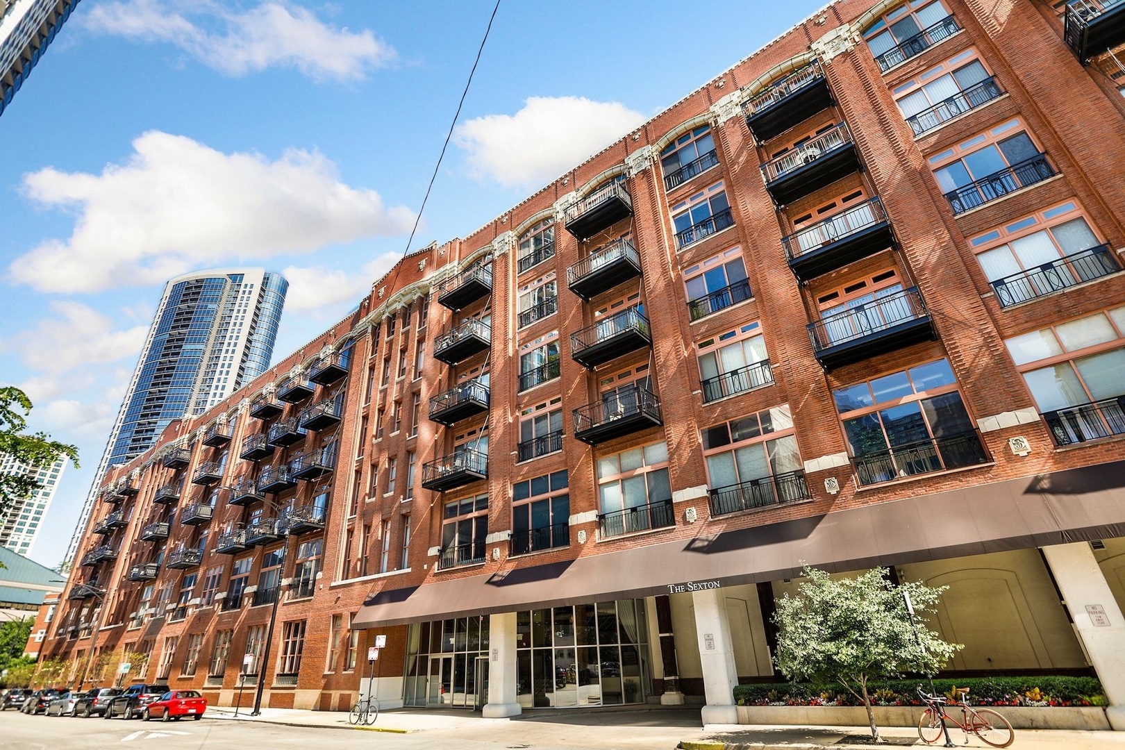 Welcome to The Sexton, a premier full-concrete loft building. This stunning 2BD/2BA residence offers nearly 1700 square feet of living space and an expansive open-concept layout with soaring 11' ceilings, abundant natural light, exceptional privacy, and unobstructed striking south-facing views from the sought-after tower tier. The recently redesigned chef's kitchen is designed for both style and function, featuring quartz countertops, a large island, striking herringbone backsplash, stainless steel appliances, and gas cooking. The spacious, fully enclosed primary suite includes a huge walk-through closet and a luxurious bathroom with dual sinks, new shower, and new soaking tub. The king-sized second bedroom provides plenty of versatility for guests or home office. Additional highlights include beautiful oak hardwood floors, gas fireplace, wall of built-ins, sunny southern exposure, private balcony, and stunning city views. One premier parking spot, directly beside the elevator, included in purchase price. Full-amenity building with 24-hour door staff, sun deck, fitness center with brand-new equipment, on-site dry cleaners, and a large 5 X 7.5 enclosed storage unit. Unbeatable River North location-just steps from East Bank Club, Easy Loop access, Surrounded by top dining, shopping, and entertainment options, this home blends luxury and convenience in one of Chicago's most vibrant neighborhoods.