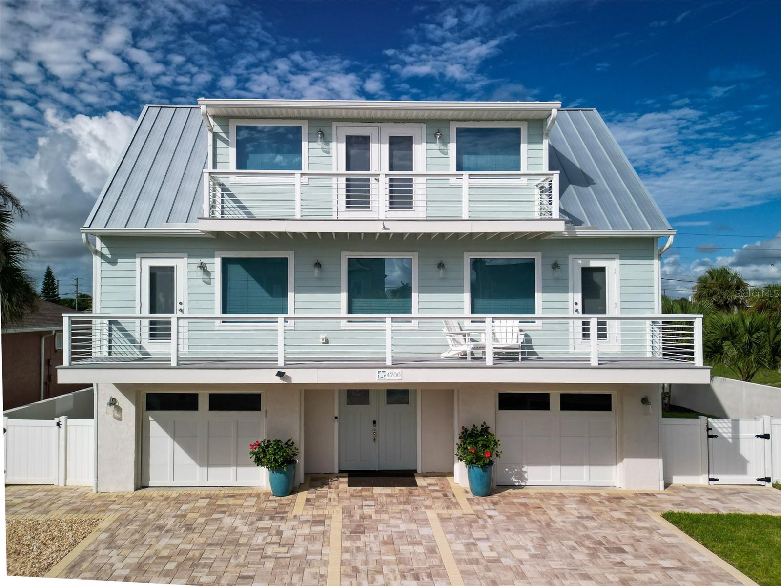 Beautifully renovated, ocean view home on prestigious Van Kleek Drive in New Smyrna Beach.  This incredible, three-story pool home features a refined, modern coastal aesthetic and is graced by high end upgrades throughout. A total renovation has completely transformed the property inside and out.  Nearly everything in this home is brand new and thoughtfully considered.  The main level features a wrap-around deck and an impressive chef’s kitchen, equipped with Thermador appliances, custom cabinetry, quartz countertops, and an oversized island ideal for gathering and entertaining.  Wide-plank flooring, designer lighting, and shiplap accents enhance the stylish, timeless vibe.  The third-floor primary suite offers a  walk-in closet, elegant bathroom, and spacious balcony with an ocean peek view—the perfect place to greet the sunrise. The fully fenced backyard boasts a resort-style pool and sun deck surrounded by lush, tropical landscaping and a comfortable, covered patio lounge, designed for relaxation and entertaining.  Additional highlights include a brand new metal roof, impact-rated windows,  a ground floor bedroom addition, a whole home generator, new HVAC, new irrigation system and dramatic outdoor lighting package as well as an enclosed, hot/cold outdoor shower.  Ideally located, across the street from the secluded beach path and just steps from the No-Drive Beach, this home offers the best of luxury coastal living—come take a look today and enjoy the best NSB has to offer.