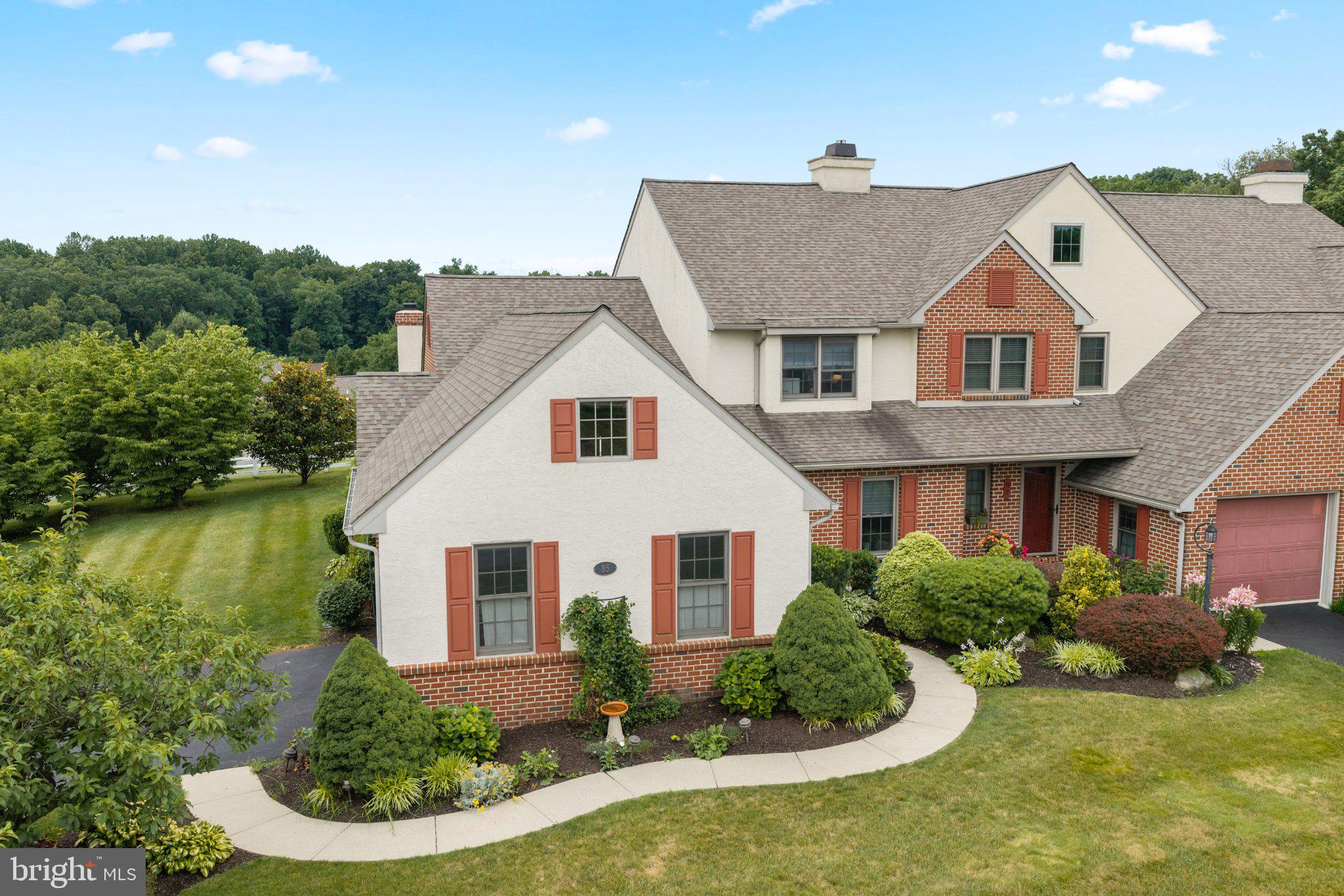 Welcome to Summerfield at Elverson, where peaceful countryside views and low-maintenance living come together in one of Chester County's most desirable communities. This beautifully updated Stoltzfus-built townhome offers one of the largest floor plans in the neighborhood and is attached to just one neighboring home, providing the feel of a single-family home with the convenience of townhome living.Designed for comfortable first-floor living, the main level features a spacious primary suite, an additional bedroom, first-floor laundry, and a dramatic vaulted living and dining room filled with natural light. At the heart of the home is a beautifully renovated eat-in kitchen featuring new cabinetry, granite countertops, a center island with seating and additional storage, and plenty of space for gathering with family and friends.One of the home's standout features is the four-season room, added by Stoltzfus in 2015, complete with heating, air conditioning, and a wood-burning fireplace—creating a cozy retreat to enjoy in every season.Upstairs, you'll find two additional bedrooms and an updated full bath, providing comfortable accommodations for family and guests.The expansive finished lower level offers exceptional flexibility and can easily adapt to your lifestyle. Whether you envision a family room, playroom, home gym, media room, art studio, or multiple gathering spaces, there's room to make it your own, along with abundant unfinished storage.This home has been thoughtfully maintained and updated with major improvements, including geothermal heating and cooling (2019), roof (2022), hot water heaters (2022), driveway (2022), first-floor windows (2023), updated bathrooms, an expanded patio (2021), and an attached two-car garage with additional overhead storage.Located in the picturesque community of Summerfield at Elverson, residents enjoy beautifully maintained open space, scenic walking opportunities, and easy access to Livingood Park, local dining, shopping, and the Pennsylvania Turnpike in nearby Morgantown. Combining generous living space, quality updates, and an exceptional floor plan, this is a rare opportunity to own one of Summerfield's most desirable homes.