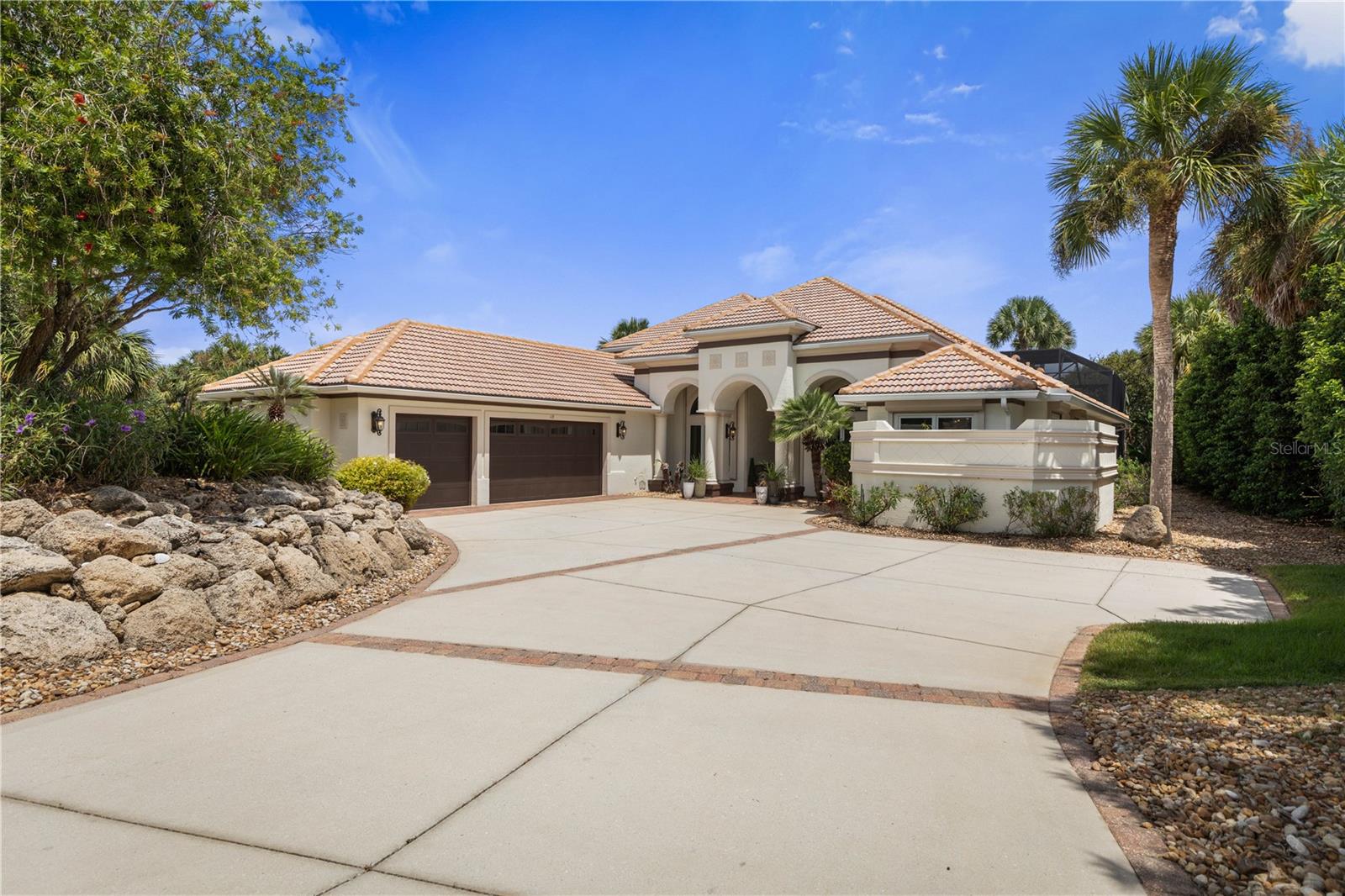Some homes impress with their features. Others create a lifestyle you can picture from the moment you arrive. Set on more than an acre of beautifully established, park-like grounds within the exclusive gated community of Island Estates in Hammock Dunes, this completely renovated waterfront residence brings together privacy, boating, sophisticated design and effortless Florida living.Mature landscaping creates a remarkable sense of arrival, while inside, the transformation is fresh, refined and thoughtfully executed. At the heart of the home, the open kitchen and family room are designed for everything from quiet mornings to evenings with family and friends. European cabinetry, a dramatic waterfall island and an exceptional collection of Sub-Zero, Thermador, Wolf, Bosch and Miele appliances make the kitchen as functional as it is striking. Custom lighting and updated electrical and plumbing fixtures continue throughout the home.The connection to the outdoors is one of the property's defining features. Stacking and pocketing glass doors disappear to open the living spaces to the screened lanai and private backyard oasis. A solar-heated saltwater pool and spa is surrounded by generous areas for lounging, dining and entertaining, while a newer MEGA-VIEW screen enclosure preserves the openness of the setting. Updated Hayward equipment and passive solar panels complete the pool improvements.Beyond the pool, lush grounds unfold toward the water, where a custom pergola and fully equipped outdoor kitchen create another destination for gathering. Fire up the grills after a day on the water or simply enjoy an evening surrounded by tropical landscaping.Follow the path to your private covered dock on the Florida East Coast Canal. Complete with water, electric and a 10,000-pound boat lift, the dock provides bridge-free access to the Intracoastal Waterway, putting boating, fishing and miles of Florida waterways within easy reach.The thoughtfully designed floor plan provides exceptional flexibility. The primary suite and an additional guest bedroom are conveniently located on the first floor, along with the main living and dining spaces and a private office. The spacious primary retreat opens toward the outdoor living area and features an elegant bath with frameless glass shower and generous walk-in storage.Upstairs, two additional bedrooms with ensuite accommodations are joined by a game/family room, wet bar and outdoor balcony, creating a private retreat for family and guests.Practical improvements are equally impressive, including hurricane protection for every door and window, Pella windows, a security system, central vacuum, circulating hot water, updated irrigation and new gutters. A 26KW whole-home generator with a 500-gallon propane tank adds another layer of comfort and peace of mind.Island Estates is a private, gated island community surrounded by coastal waterways. Optional Hammock Dunes Club membership is available separately, offering access to exceptional golf, dining, tennis, fitness and club amenities.Beautifully renovated and designed to embrace both land and water, this is a home where mornings begin beside the pool, afternoons are spent on the Intracoastal and evenings end beneath the palms. The home is ready. The dock is waiting. All that's left is to enjoy the Island Estates lifestyle.