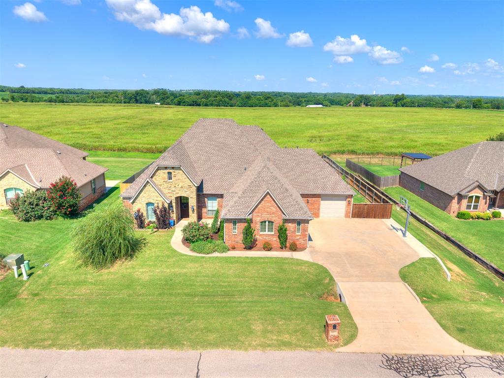 Some homes simply check the boxes. This one changes the way you live. Perfectly positioned on over half an acre in the highly sought-after Land Run Addition and within the Norman School District, this custom-built home was designed for making memories. From quiet mornings with coffee watching the sunrise to evenings spent on the patio, this home allows you to slow down. Step inside to vaulted ceilings, rich hardwood floors, and a thoughtfully designed floor plan offering 2,840 square feet of comfortable luxury. The dedicated study provides the ideal work-from-home space, while the open living areas seamlessly connect for everyday living and effortless entertaining. The kitchen is truly the heart of the home, featuring a luxury double oven, abundant counterspace, and everything needed to host holidays, birthdays, or casual weeknight dinners. Spacious covered patio extends your living space outdoors with a beautiful fireplace overlooking the backyard and the stunning heated chlorine pool that was just installed in 2022. The private primary suite offers a peaceful retreat with a spa-inspired bathroom featuring a spacious walk-in shower and the convenience of a laundry room that connects directly to the primary closet. Everyday tasks become just a little easier with a functional laundry room complete with its own sink. Two secondary bedrooms share a Jack and Jill bathroom, providing both privacy and convenience, while the upstairs bonus room with its own half bath offers endless possibilities as a media room, game room, guest retreat, or additional living space. Recent updates include fresh interior paint throughout the entire home, brand new carpet upstairs and on the staircase, and a new Class 4 impact-resistant roof. One advantage of Land Run Addition is the flexibility it offers. Shops are allowed, giving you room for hobbies, extra storage, or your dream workshop. Storm shelter in the garage provides ultimate peace of mind, creating a place to call HOME.