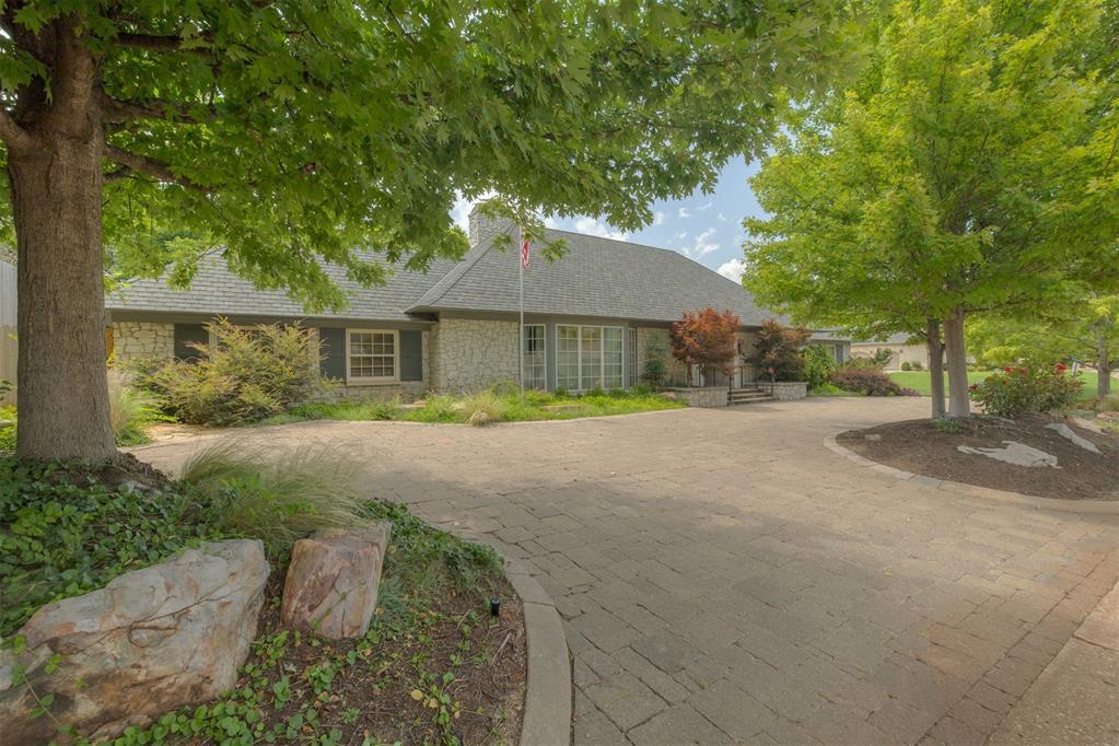 Beautiful classic stacked stone traditional on one level at the corner of 68th and Country Club Drive. Circle drive off Country Club Drive brings guest to front door while entrance to garage is off separate driveway off 68th street. From the front door off circle drive a large entry greets you and leads you to an open floor plan with big rooms, high ceilings and lot’s of tall and wide windows throughout including beautiful bay window in front living area. Two large living areas each with high ceilings separated by 2 way stone fireplace.The family and friends entrance is through a small courtyard off the driveway by garage that leads to a door into kitchen. Charming spacious kitchen and adjacent eating area. Two beds on one side of the house and guest bed on the other end. Each bed has a private bath. Covered and open patios in very private tree shaded backyard. Wood and brick floors. Attic is very big and the tall roof would allow adding additional square footage upstairs. You immediately see and feel the quality of the materials throughout and the care taken in maintaining them. This is a true gem and an excellent location.