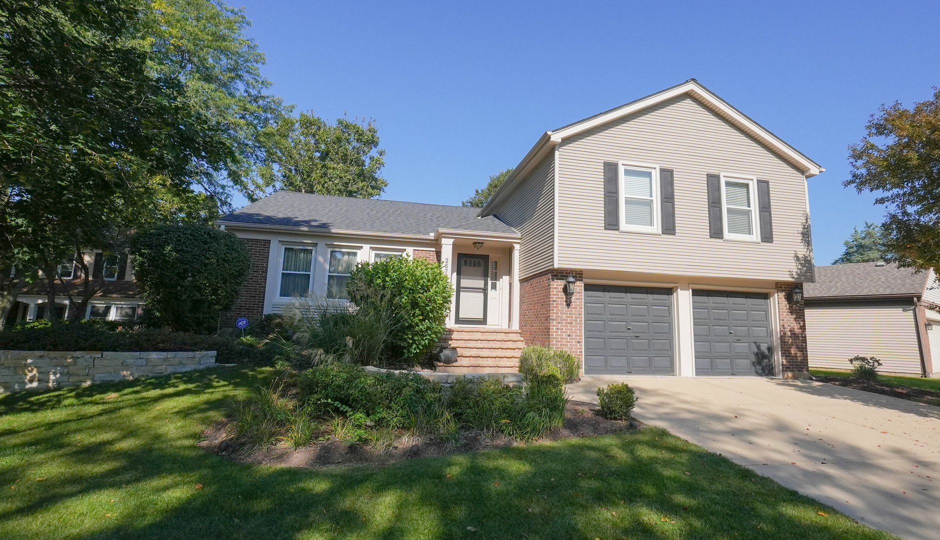 Spacious split level in beautiful Green Trails backing to the walking path! Many updates throughout including remodeled kitchen with 42" cabinetry, wall of pantry cabinets, roll-out drawers, granite countertops, large island with seating, stainless steel appliances, tile backsplash & skylight. The main level is versatile with flexible space - the front living room features triple windows overlooking the front yard & is connected to a dining room - both with hardwood flooring which opens to the family room with brick fireplace right off the kitchen. Upstairs there are 4 bedrooms & 2 full baths including a master suite where the hardwood floor continues plus a walk-in closet and remodeled full bath. A few steps down from the main level is a bonus family room with laundry & garage access plus sliding glass doors to the lower level patio. There's one more level - a spacious sub-basement great for workout area, playroom, storage, etc. This beautifully maintained home also features a hardwood staircase & 6 panel sold core doors. Don't miss the inviting backyard setting with 2-levels of brick paver patio, sit wall & awning, established trees & lush landscaping. New Roof (2023), Furnace & AC approx 10 years old. HURRY!