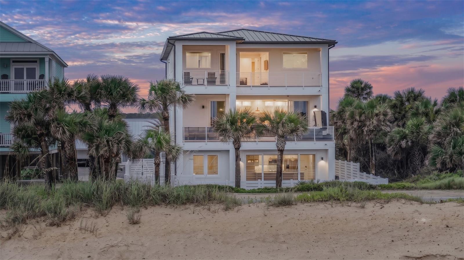 Virtually Staged. A shoreline masterpiece unlike anything else on the Golden Mile, 2214 N Central Ave offers the rare advantage of an FDOT-maintained seawall, allowing its owner to experience paradise without paying the price of private seawall maintenance. This one-of-a-kind modern oceanfront estate was completed in November 2024. Designed as a legacy property with no expense spared, this residence offers contemporary elegance and uncompromising quality.  Anchored between the Atlantic Ocean and the Intracoastal Waterway, A rare dual-water view and an incomparable location directly on A1A, high and dry in flood zone X. Crafted as a luxury coastal fortress, the residence is constructed entirely of reinforced concrete across all three levels, with approximately 24 concrete pilings extending 25 feet deep. Built for peace of mind and durability, the home features impact windows, doors, and an impact-rated garage. A standing-seam aluminum roof, underground drainage systems, foam insulation, and elevated construction in Flood Zone X deliver a secure, energy-efficient residence engineered to endure while providing exceptional comfort and remote control via your phone. The Smart home’s thoughtful design supports a range of lifestyles, whether envisioned as a full-time coastal sanctuary, a lock-and-leave luxury retreat, a multigenerational estate, or a short-term rental. Every level captures the surrounding beauty, pairing unforgettable water views with refined interiors and exceptional craftsmanship. Elegant, timeless, and truly incomparable, 2214 & 2216 N Central Avenue represent a rare opportunity to own one of Northeast Florida’s most distinctive modern oceanfront estates. More than a home, it is a lifestyle defined by peaceful luxury, enduring quality, and views that will inspire generations.