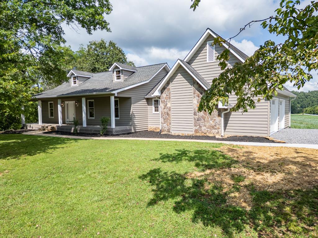 This beautifully updated 3 bedroom 3 bath home sits on 7.43 acres of unrestricted property with over 1,000 feet of frontage on Brasstown Creek. Enjoy year-round creek, mountain, pastoral, and farmland views from your back porch, perfect for soaking in stunning sunsets and the peaceful sounds of the creek. Inside, the living room welcomes you with gleaming hardwood floors, a soaring cathedral ceiling, and direct access to the back porch. The updated kitchen features painted cabinets, granite countertops, a new farm sink, and brand-new stainless steel appliances. Just steps away, you'll find a charming coffee/wine bar with butcherblock counter and open shelving, as well as additional storage. The split-bedroom floor plan ensures privacy for the spacious primary suite, which boasts a walk-in closet and a beautifully updated bath with a tile shower, double vanity, and large linen closet. Two additional bedrooms on the opposite end of the home share a full bath with a tub and tile surround. A designated laundry room with ample cabinetry, a farmhouse laundry sink is steps away from the kitchen and allows access to the oversized freshly painted garage, with new garage doors. The home features hardwood floors throughout, ceramic tile in the bathrooms, solid wood interior doors, and wood windows for timeless character. The partially finished walk-out basement includes the third full bath and offers versatile space for hobbies, a home gym, or storage. Solar panels provide enough electricity to power the entire home. Freshly painted inside and out, this home is truly move-in ready. All this is just minutes from town, wineries, Chatuge Lake, The Appalachian Trail, North Georgia, schools, and endless outdoor adventures. Come experience the best of peaceful country living. Enjoy fishing, playing in the creek, gardening, and the amazing views from your own private retreat.