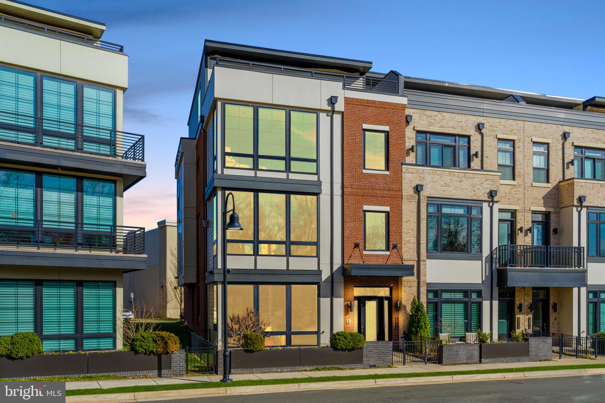 Discover Unparalleled Luxury in One Loudoun. Experience resort-style living in this stunning, rarely available, end-unit townhome, with nearly 5,200 square feet of refined space and a private in-home elevator. Overlooking the park's lush greenery and offering breathtaking sunset views, this home delivers a serene escape immersed in vibrant community energy - right at your doorstep.Impeccably updated and meticulously maintained, it masterfully blends urban sophistication with effortless lock-and-leave convenience. Ideal for embracing One Loudoun's active lifestyle or enjoying low-maintenance elegance, this residence must be seen in person to appreciate its superior craftsmanship and unbeatable location. Abundant natural light floods the open, airy layout, making entertaining seamless and everyday living a delight. Thoughtful design and premium finishes create the privacy and tranquility you crave, elevated by distinctive architectural details that define true luxury.Highlights Include:10-foot ceilings on the first three levels and 9-foot on the fourthPrivate elevator servicing all floorsAdvanced smart home automation and security for effortless controlMAIN LEVEL: A bright, welcoming great room filled with sunlight - perfect as a flexible entertaining space, family hub, or home gym. A separate bonus room with generous closet, full bath featuring a luxury hydrotherapy walk-in tub, and direct garage access complete this level. LEVEL 2: The entertainer’s heart of the home centers on a chef’s-caliber kitchen with premium Wolf appliances, Sub-Zero refrigeration, custom designer cabinetry, and a massive quartz island. Adjacent sits a spacious area with built-ins, flowing to the rear deck ideal for al fresco dining and grilling. The open-concept design seamlessly connects to the dining area, gracious living room with fireplace and private office - all with park views. A convenient powder room rounds out this floor. LEVEL 3: Retreat to your serene primary suite framed by floor-to-ceiling windows with custom automated treatments for privacy and sophistication. The spa-inspired primary bath offers dual vanities, a deep soaking tub, and an oversized frameless walk-in shower. An expansive custom walk-in closet provides unparalleled organization. Two additional oversized secondary bedrooms each feature en-suite full baths with frameless walk-in showers and large closets. An upgraded laundry room with built-in cabinetry, sink and linen storage is conveniently located here as well.LEVEL 4: A versatile bonus room overlooks the private rooftop terrace, paired with a generous bedroom and full bath - perfect for guests or multigenerational living. The highlight is your exclusive rooftop terrace: equipped with gas fire-pit for cozy evenings, retractable (and lighted) awning for shaded relaxation, and panoramic sunset vistas over the surrounding green space.Premium Extras: EV car charger - Comprehensive smart home automation - Ultraguard security system -Probiotic and electronic air filtration - Whole-home water filtration - Towel warmersAMENITIES: The Club at One Loudoun features meeting rooms, entertainment spaces with catering kitchen, half-court basketball, outdoor pool (with toddler area), tennis and pickleball courts, sand volleyball, dog park, and playgrounds. The Barn hosts year-round concerts, events, and gatherings in its amphitheater.PREMIUM LOCATION: Directly across from the park's growing trail system and scenic pond. Just one block to premier shopping, dining, entertainment, farmers markets, and everyday conveniences. Quick access to major highways, Dulles International Airport, and the DC metro area.This is more than a home - it's an exceptional lifestyle blending urban vibrancy with suburban charm. If you've been searching for the perfect fusion of luxury, location, and low-maintenance living, your search ends here. Schedule your private tour today!