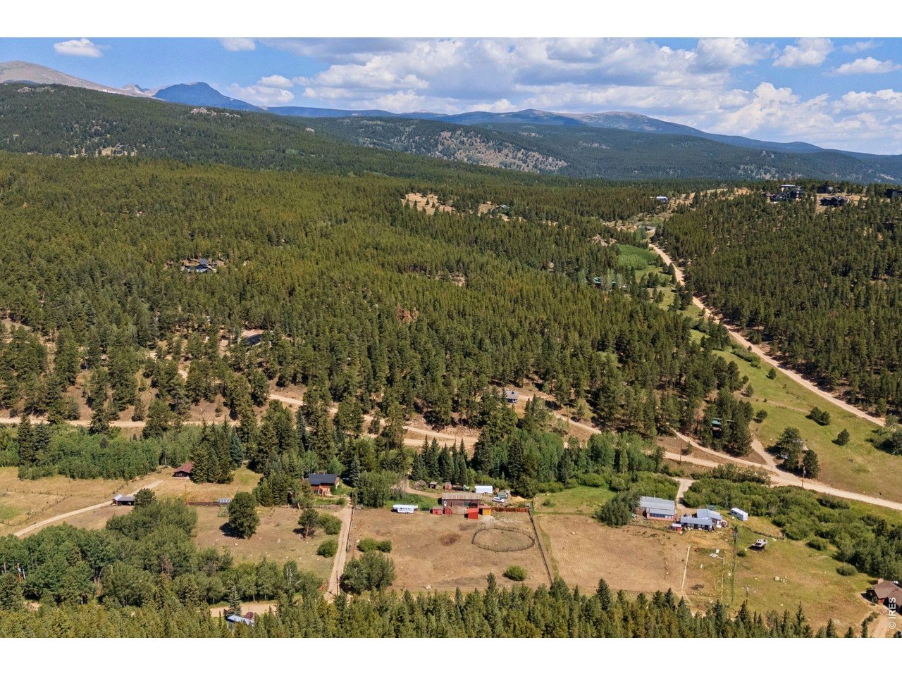 Bordered by forest in a quiet south-facing valley just half a mile above downtown Nederland, this rare 4.36-acre flat parcel offers usable land, privacy, mountain views, and true proximity. The property holds 3 separate buildable lots - exceptional upside near town limits. No true comparables. An old-growth ponderosa anchors the sunlit meadow. Tucked off historic Caribou Road sits a warm mountain home, updated with care yet ready for its next chapter - ideal as is or a developer's dream. Recent improvements include a renovated kitchen, updated bath, new metal roof with snow dams, 2022 Navien boiler, master-electrician wiring, new solid wood doors and hardware, refinished oak floors in natural eco oil, new radon mitigation system, and a no-freeze spigot. The open main level features a skylight, forest views, and a freestanding hearthstone wood stove. Flexible 2-3 bedroom, 2-bath layout includes an office/studio and a black Porcelanosa black tiled entry. Below, a Saltillo-tiled walkout with private entrance, bedroom, and living space opens to a passive-solar greenhouse that grows food at 8,000 feet. Flat fenced pastures with Aspen groves, a northern creek, and a spring vernal pool complete the setting. A 250-ft well (permitted to irrigate one acre) and a 40x100 concrete-floor shop stand ready for barn, studio, workshop, or more. Three lots already carry building determinations for single-family home, well, and septic; a fourth is restorable with county confirmation. An upper and lower drive provides dual and easy access. Minutes to Ned's coffee, brewery, Carousel of Happiness, and Barker Reservoir. Ten minutes to Eldora, thirty to Boulder, and ninety to DIA. Rare properties like this move quickly. Bring your vision.