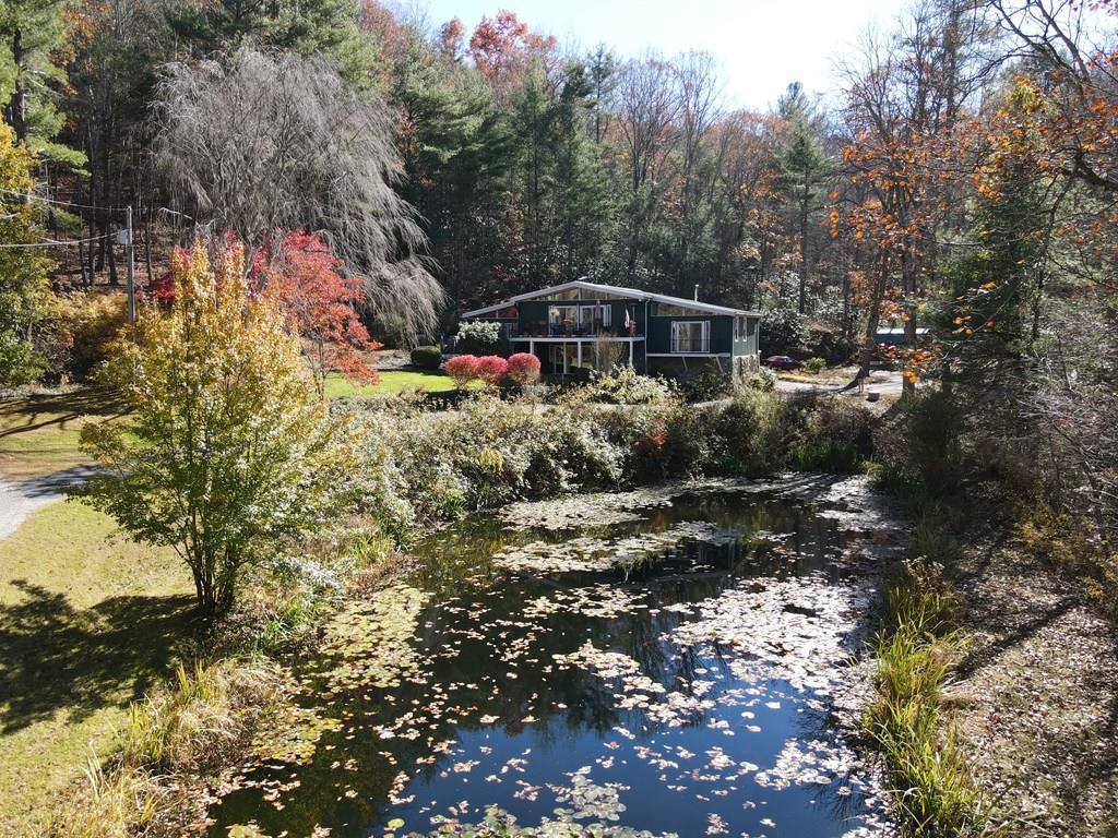 This home was designed to take in the peacefulness of the private woods and pond that surrounds it. This Mountain Retreat offers it all. A nature lover's paradise. Tucked away in the beautiful mountains of Elk Creek, this stunning retreat offers peace, privacy, and an unmatched connection to nature. As you follow the winding driveway, you're greeted by a home perfectly perched on the mountainside, surrounded by natural, park-like landscaping with a gentle creek flowing nearby. Every detail of this property invites you to slow down and savor the beauty around you. Inside, the home is warm and welcoming, featuring wood floors, striking rock fireplaces, vaulted ceilings and large windows and doors that frame mountain and woodland views from every room. The spacious living room and formal dining area are ideal for gathering with friends and family, while the kitchen steals the show with its whimsical rock surround around the stove—a true focal point that adds rustic charm. The primary suite offers comfort and privacy, complete with a large garden tub and separation from the other bedrooms. On the lower level, you'll find a generous family room and a game room, creating plenty of space for entertaining or relaxing after a day outdoors. Step outside to multiple decks and covered patios that make it easy to enjoy the serene surroundings year-round. A large 20x50 detached garage has plenty of space ample storage for outdoor gear, gardening tools, or hobbies. Whether you're seeking a full-time residence or a weekend getaway, this property is the perfect haven for the nature enthusiast—where the sound of the creek and the beauty of the landscape come together flawlessly. Qualified buyers are encouraged to schedule a private showing to experience this extraordinary mountain retreat firsthand.