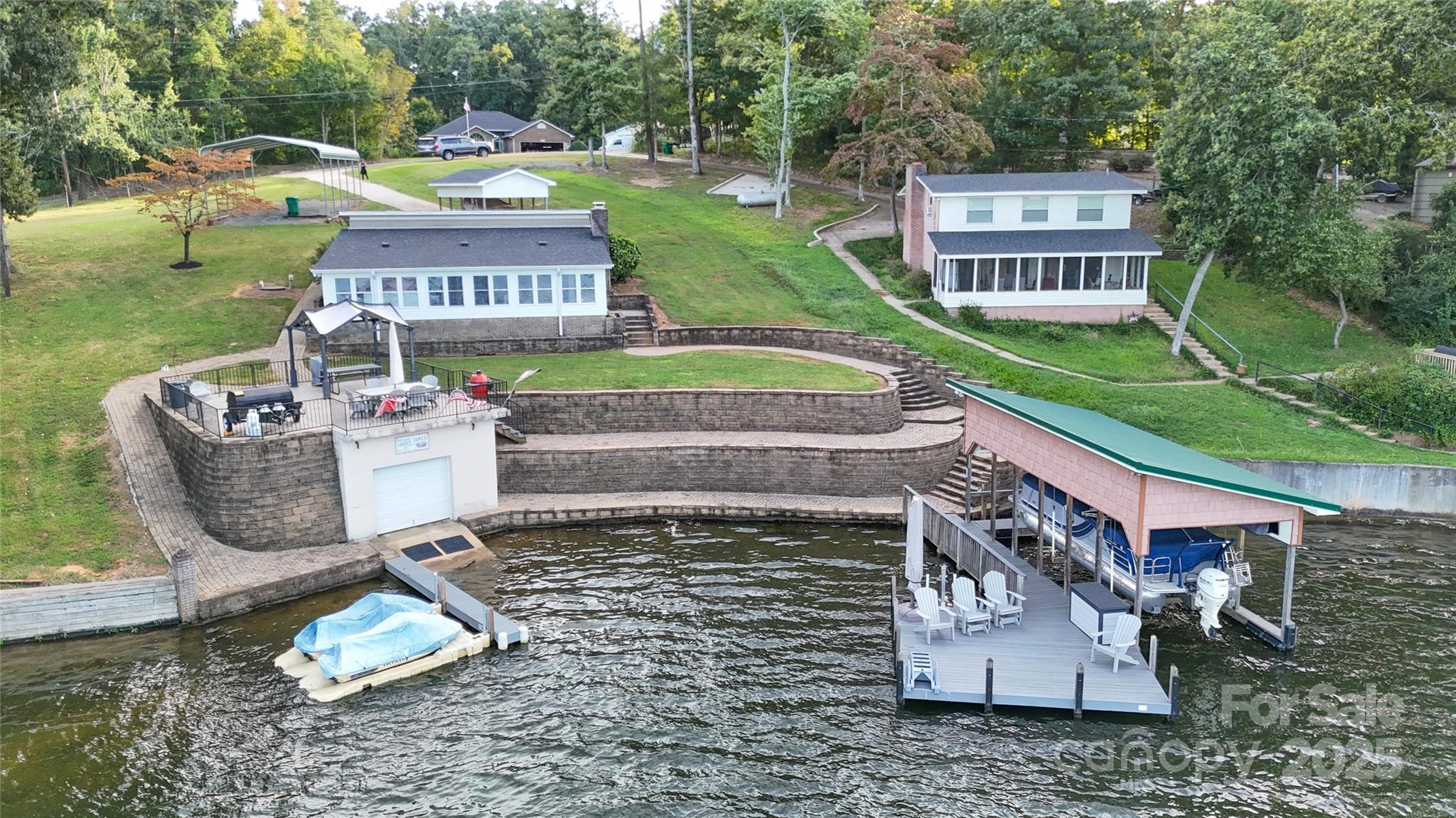 There are miles of main channel views from this 2 BR / 1 BA waterfront home on Lake Tillery. Recently remodeled with LVP flooring, tile shower, paint, updated kitchen with quartz counter tops. The living room offers a fireplace insert that is wood burning. The waterfront side is open to the lake with tons of glass for extraordinary views. There is one slip boathouse / dock and an inground boathouse with a fenced patio on top for entertaining and grilling out. The retaining walls offer a gentle slope and easy walk to the dock. Deep water at the boathouse as well. Concrete driveway and two detached carports. Only minutes away from Downtown Norwood for shopping, groceries and dining out. The City of Norwood owns the EF One sewer pump and is responsible for any maintenance or repairs that might arise in the future. Come find your Lake Tillery waterfront retreat at this property !!