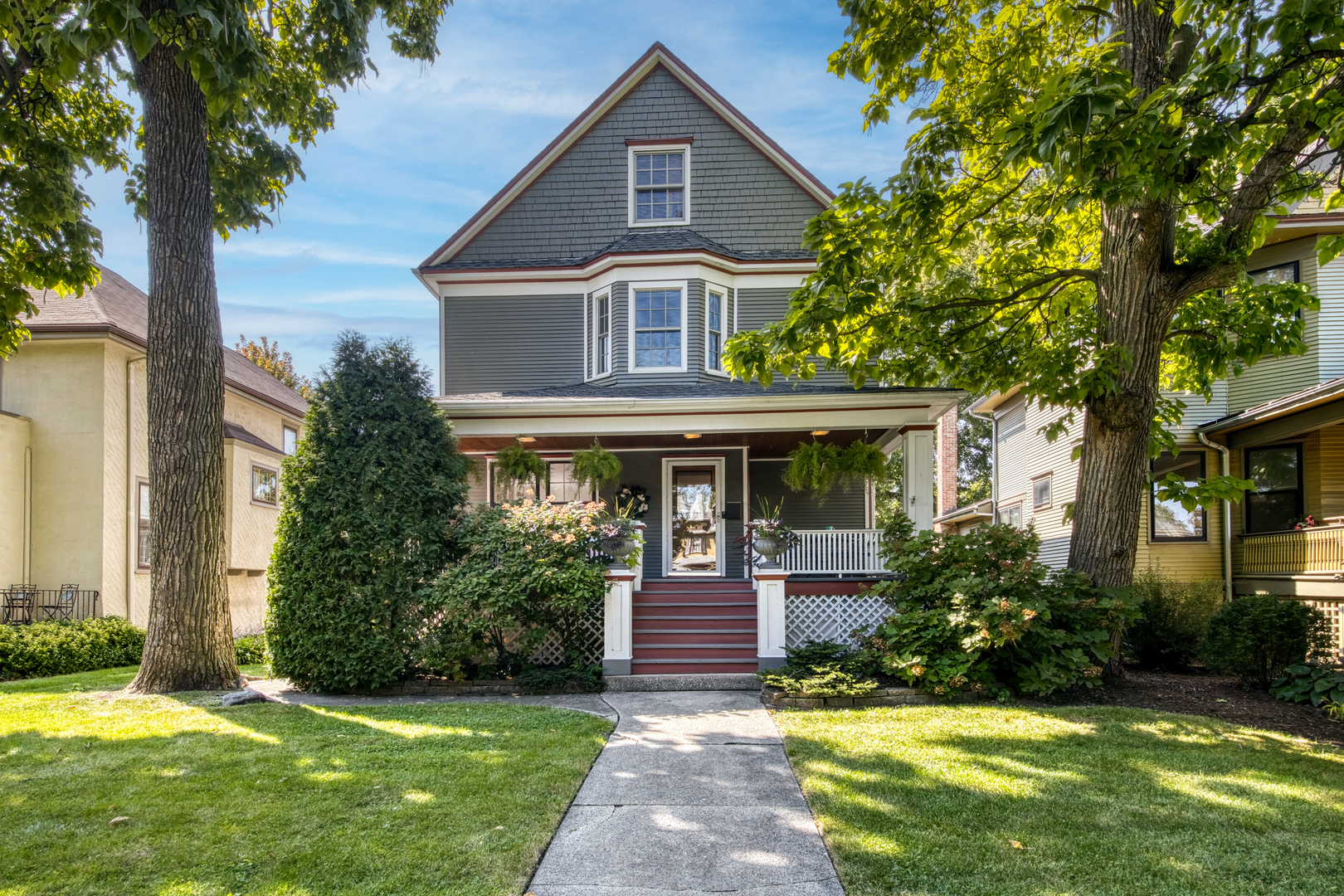 Tucked away on a quiet, tree-lined cul-de-sac in the heart of downtown Oak Park, this timeless Victorian welcomes you with its wide front porch and charming character. From the moment you step inside, you'll feel instantly at home. Beautiful hardwood floors lead you into a sun-drenched living room anchored by a cozy gas fireplace. A separate formal dining room sets the stage for holiday gatherings and special celebrations.   The spacious family room features a vaulted ceiling, wood-burning fireplace, and custom built-in bookcases with a dedicated work area. An open kitchen offers rich cherry cabinetry, ample counter space, and plenty of room to cook and gather. Upstairs you'll find four spacious bedrooms, including a primary suite with a full bath and custom closets. A second-floor laundry room adds everyday convenience. The updated third-floor suite includes a fifth bedroom, a full bath, and a flexible space-ideal as a guest suite, home office, playroom, or workout area. Step outside to your private, fenced backyard with plenty of space to relax, entertain, or play. A two-car garage plus a parking pad for three additional vehicles completes the outdoor space. Prime location-walk to top-rated schools (elementary, middle, and high), restaurants, cafes, library, pool, train, and the beloved Oak Park Farmers Market.