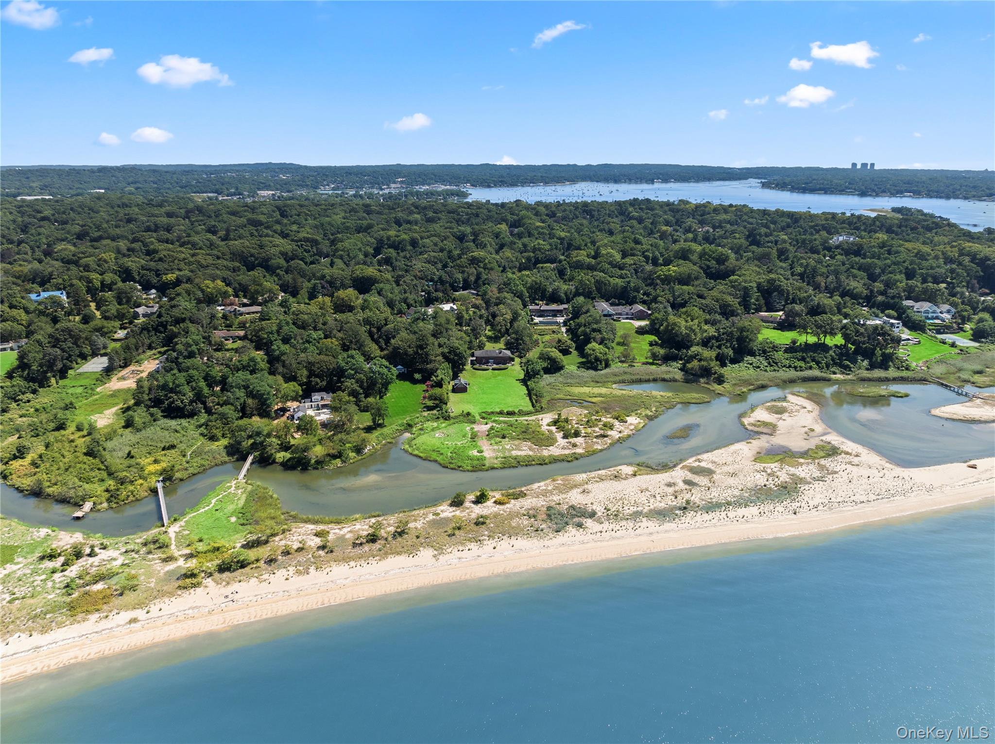 Sunset Beach - A Private Coastal Retreat on Long Island Sound. Step from your backyard into the pristine waters of the Sound — where coastal luxury meets everyday living. Welcome to Sunset Beach, an enchanting 10-room brick estate nestled on five private, fully fenced acres along one of Long Island’s most coveted waterfronts. From jet skiing and paddleboarding to horseback riding along the shore at sunset, this is a lifestyle few can imagine — and even fewer can call their own. This expansive home features six bedrooms and seven-and-a-half baths, with grand indoor and outdoor spaces designed for both entertaining and serene daily living. The first floor opens with a dramatic foyer and direct water views, an elegant living room and cozy den sharing a double-sided fireplace, a formal dining room, and a eat-in kitchen. A stylish floating staircase leads upstairs, while a powder room, laundry room, and maids’ quarters with private bath offer practicality and privacy. On the second floor, you'll find five bedrooms, including two suites with marble baths and double closets, and another with a granite and granite bath overlooking the Sound. The principal suite is a showstopper, offering a Jacuzzi tub, vanity, water views, and a private great room with wet bar, which could also serve as an alternate primary bedroom with three-sided exposure and spiral staircase access to the rear yard. A third-floor walk-up attic provides an oversized closet, while the unfinished basement with exterior entrance is primed for completion — which already includes a full bathroom  and wet bar. A separate one-bedroom duplex cottage includes an attached two-stall barn, with the option to convert the lower level back into a two-car garage — perfect for equestrian use or guest accommodations. The property’s five acres are lush, level, and gated, featuring a rear open meadow ideal for an in-ground pool, tennis court, or pickleball court. With ample space to expand and personalize, the estate offers unmatched potential to craft your dream home, fully tailored to your vision. With direct beach access, panoramic water views to Manhattan, and breathtaking sunsets, Sunset Beach blends timeless elegance with natural beauty in a way that few properties can. View 3D Tour and Floor Plan.