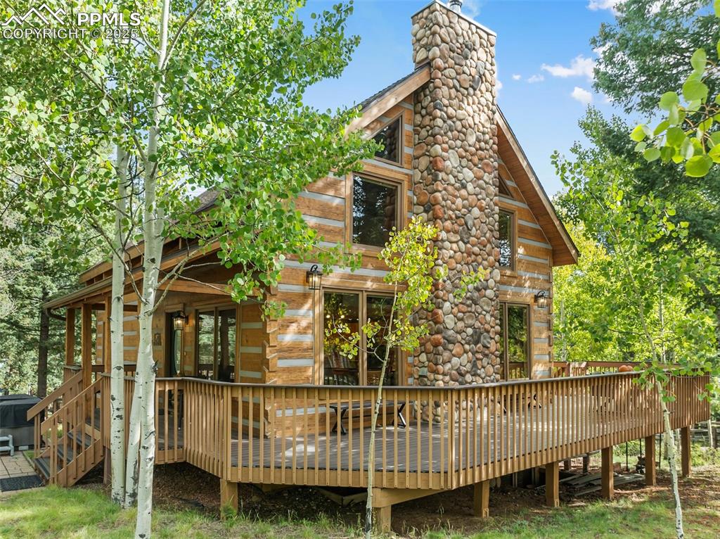 Nestled amongst a mix of Aspens & Pines just minutes from Downtown Woodland Park, you’ll discover a truly unique property—a custom dove tail hand hewn log home that defines mountain living at its finest. This remarkable residence seamlessly marries the charm of a traditional log cabin with the convenience of modern amenities, offering a one-of-a-kind sanctuary for those seeking a convenient mountain escape. The open-concept living space features a magnificent stone fireplace, perfect for cozy evenings by the fire, vaulted tongue and groove ceilings and expansive windows that flood the space with natural light. The interior exudes genuine rustic elegance. This 3-bedroom, 3-bathroom home offers an unparalleled blend of comfort and nature. The lower level includes a dry sauna, family room(currently used as extra guest quarters), and a guest bedroom with outside entry and full bathroom. Outside you’ll enjoy a large wrap around composite deck, hot tub, and a fully fenced in .97-acre lot for pets and family members. Florissant Fossil Beds National Monument, Dome Rock State Park, Mueller State Park, Rampart Reservoir, and National Forest are all within a 30-minute drive for your weekend adventures. Fishing at 11 Mile Reservoir, Spinney, and the "Dream Stream" are all within a 45-minute drive. Skiing at Breckenridge is just under 2 hrs. away. Welcome to your small mountain town in Woodland Park, CO.... "The city above the clouds"!