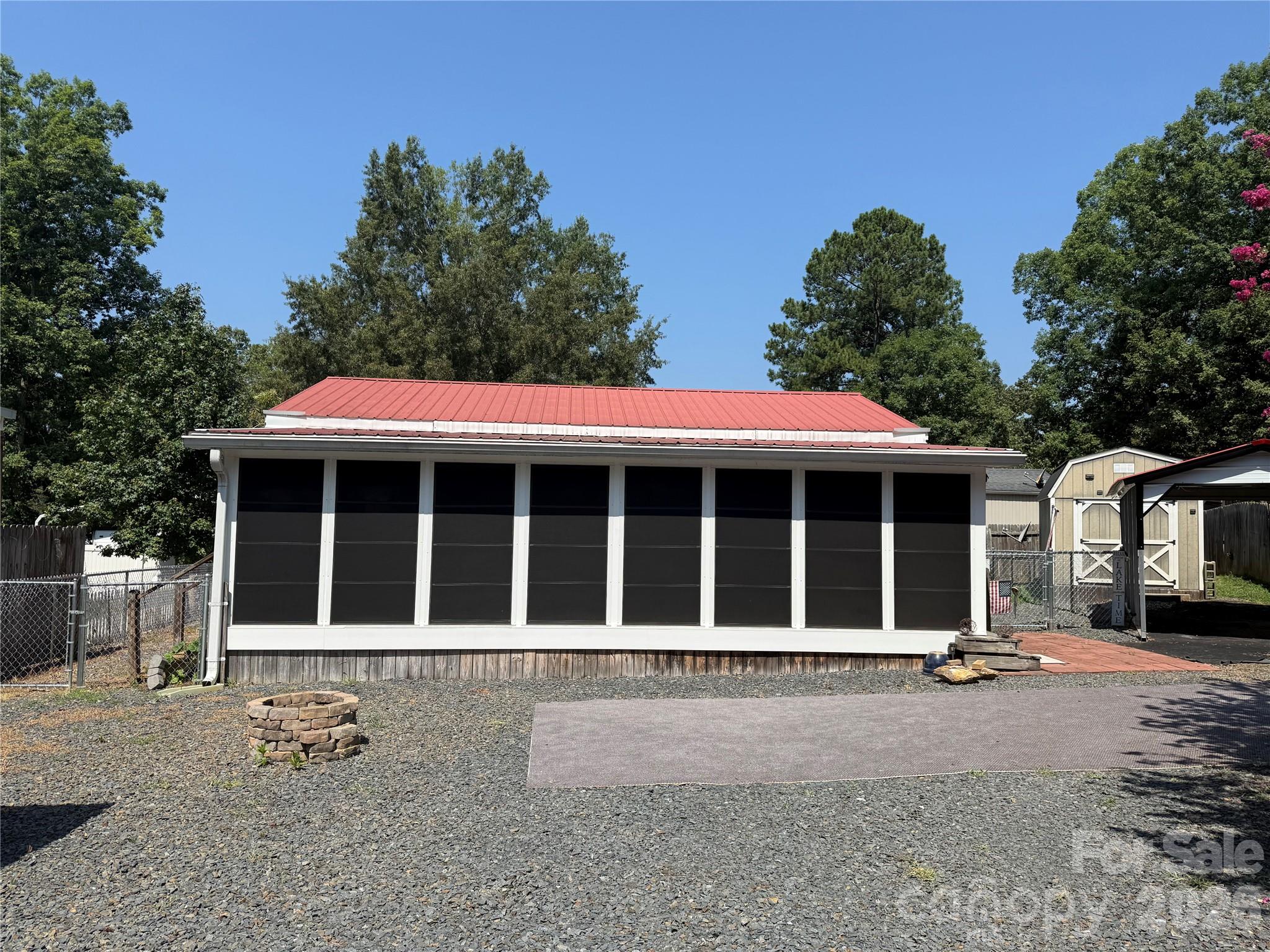 Welcome to one of my favorite units here in the park. Quiet, Cul-de-sac unit, flat, mostly gravel, low maintenance and near the entrance for easy access. 30' camper that has been completely redone, full addition with block foundation. Camper and addition have real HVAC. The enclosed porch with Easy Breezy Windows, new blinds and a mini-split for climate control comfort is currently being used as a TV room. Includes a table with chairs, oversized bean bag chair, rock n glide chair and a bungee chair. Large room with plenty of space for all your guests. Move into the added living room, with sofa, recliner, TV, table and trundle bed. Also in the addition is the primary bedroom with nice space and good storage. The camper is now a lovely kitchen with really nice appliances, updated bathroom with alcove tub/shower combo, new vanity and real potty. Small area with a twin bed for additional sleeping. Fenced back yard for your dogs. New flag pole. There is a carport for your car or boat. A shed in a box for your golf cart. A fully insulated building with power, water and a washer/dryer to remain and a loft. Great lot here in the park. Come and see if this can be your "Happy Place".All buyers must be with a realtor to gain entry to the park.