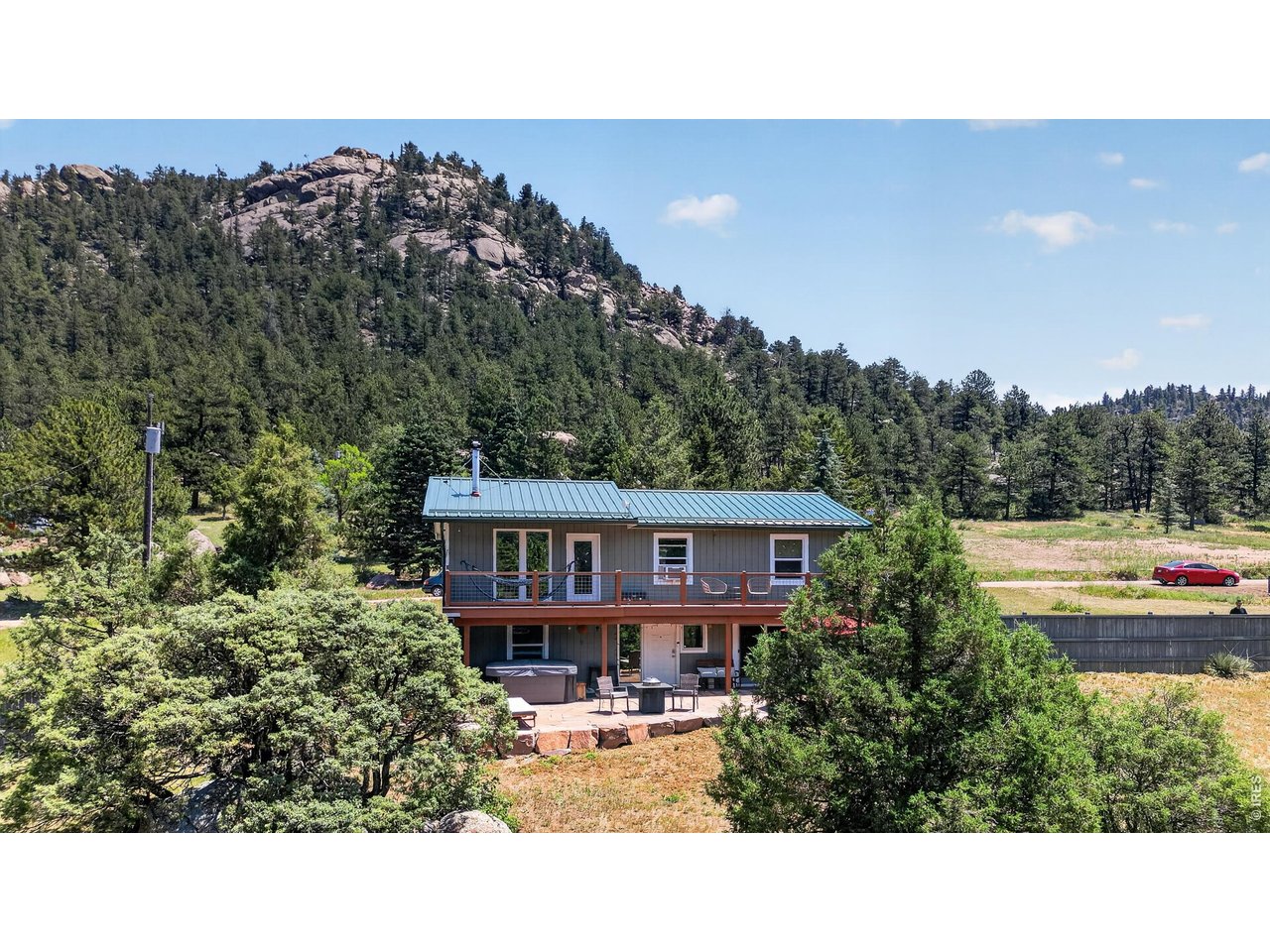 Stunning Views, Upgrades & Ultimate Privacy with National Forest in every direction! Nestled in the mountains of Lyons, this beautiful home offers breathtaking scenery, and the Colorado lifestyle you've been dreaming of. The open floor plan is filled with natural light thanks to picture windows showcasing the forest from every room. The remodeled kitchen features updated cabinetry, modern finishes & newer appliances, while beautiful wood flooring and exposed brick in the bathroom create a warm, contemporary feel throughout. Step out onto the new decks and create the perfect place to enjoy your coffee, entertain friends, or unwind while taking in the surroundings. Plus, enjoy the massive, locally sourced Lyons Sandstone patio and retaining wall, complete with a new hot tub and new pergola for extra privacy; multiple outdoor gathering spaces that blend seamlessly with the natural landscape. A fully fenced yard offers room for pets & recreation all while maintaining privacy. A 1,000 gallon rain collecting cistern makes gardening a cinch. The spacious walkout basement features a bedroom w/ ensuite & family room with up/down blinds; ideal for guests, multi-gen living & flex space. This home offers peace of mind! Major improvements; new metal roof, front door, exterior paint, windows, electrical panel, water heater, water line, and a newer fence. With so many significant upgrades completed, you can simply move in & enjoy mountain life. Adventure begins outside your door w/ nearby trails, wildlife and endless opportunities for outdoor recreation. You'll enjoy a level driveway with year round access to US 36, high speed internet(fiber optics recently added along US 36), just 10 min to Lyons, 15 to Estes Park & 30 to Boulder. Whether you're looking for a full time residence, mountain retreat, or the perfect place to embrace Colorado's outdoor lifestyle, this exceptional home delivers the combination of privacy, modern updates, stunning views, and unbeatable access to nature.