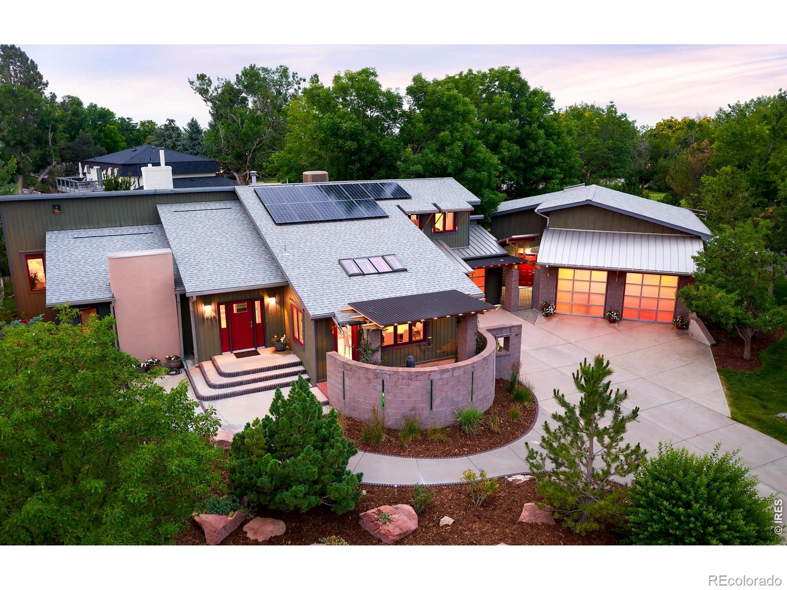 Indulge in resort-style living in Park Lake - one of Boulder County's most coveted & iconic enclaves - just three miles from Boulder yet offering a serene, world-away ambiance. This exceptional contemporary home blends eco-modern architecture with upscale finishes, including metal roofing accents, an integrated solar array, artfully mixed-material siding & masonry, bold architectural color palettes, & beautifully clean, sculptural lines. Light & airy with vaulted ceilings & skylights, the residence has been thoughtfully updated with refined, designer-level finishes. Large-format marble tile floors, art-niche built-ins, steel & cable railings, hardwood floors, & curated lighting create a sophisticated, gallery-like ambiance. The gourmet kitchen impresses with 42-inch custom cabinets, granite countertops, & high-end Viking & Dacor appliances, seamlessly adjoining the formal dining area for entertaining. The primary suite offers a quiet retreat with a beautifully remodeled bath featuring dual a dual sink vanity, zero-edge walk-in shower, & generous closet spaces. Additional bedrooms enjoy their own large walk-in closets, while the lower level expands the living experience with a spacious family room, recreation room, & a climate-controlled wine-tasting room. A true haven for car enthusiasts, the property includes an attached 1-car garage plus an impressive 1,458 sq ft detached garage & workshop complete with a huge storage loft, hoist, car lift, compressor, & dedicated work areas. Surrounded by lush lawns & mature trees, the property's outdoor oasis centers around an impressive swimming pool with integrated hot tub and a charming pool house offering a snack bar, separate locker rooms, & generous patio spaces ideal for gatherings & summer relaxation. Set in an exceptional location, Park Lake is surrounded by Teller Farms Open Space with direct access to trails, the neighborhood lake, BBQ areas, & picnic spots - an extraordinary property in a truly remarkable setting!!