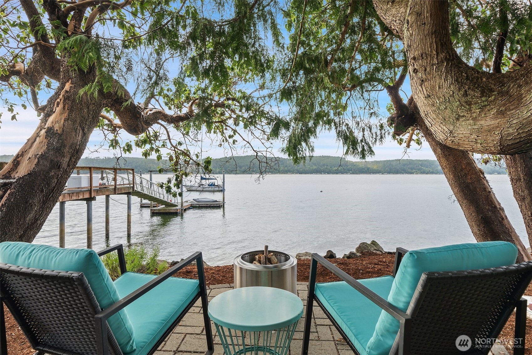 Welcome to your private Hood Canal sanctuary, where 50 feet of low-bank waterfront, owned tidelands, and breathtaking Olympic Mountain views set the stage for an extraordinary coastal lifestyle. Nestled along the coveted South Shore, this custom-crafted home offers a rare blend of comfort, design, and natural beauty. The upper level is designed to impress, with vaulted ceilings, designer wallpaper, and an open-concept layout that captures stunning views from the living room, kitchen, and dining area. Step out onto the expansive deck to enjoy fresh salt air, passing boats, and unforgettable sunsets. A cozy bedroom and ¾ bath complete this level. On the main floor, a spacious flex room offers versatility for guests, additional sleeping area, a media retreat, or private office, complemented by a full bath and generous storage. An oversized garage and ample driveway parking provide both convenience and functionality. Outdoors, the fully fenced waterside setting features multiple patios and direct, easy access to your private beach.  Enjoy kayaking, shellfish harvesting, or sunsets evenings by the fire as the canal glows.