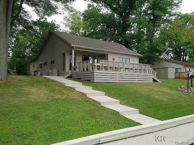 Discover this stunning Wixom Lake waterfront home featuring 104 feet of prime lake frontage! Nestled on just over an acre, this property offers expansive lakefront living with breathtaking panoramic views from the front deck and yard.

The well-maintained residence includes a spacious 3-bedroom layout with an open floor plan. Enjoy a beautifully updated kitchen, new wood laminate flooring, and a lakeside master bedroom with charming log-enhanced walls. The natural fireplace and large living room doorwall leading to the deck add to the home's appeal.

Additional features include a 14x22 bunkhouse, recently renovated for comfort with heating and window A/C, perfect for family and guests. The 28x40 pole barn, with concrete floors and three garage doors, provides ample storage and easy access.

Situated on a double lot that is over 420 feet deep and more than 100 feet wide, this property also boasts towering mature trees and much more.