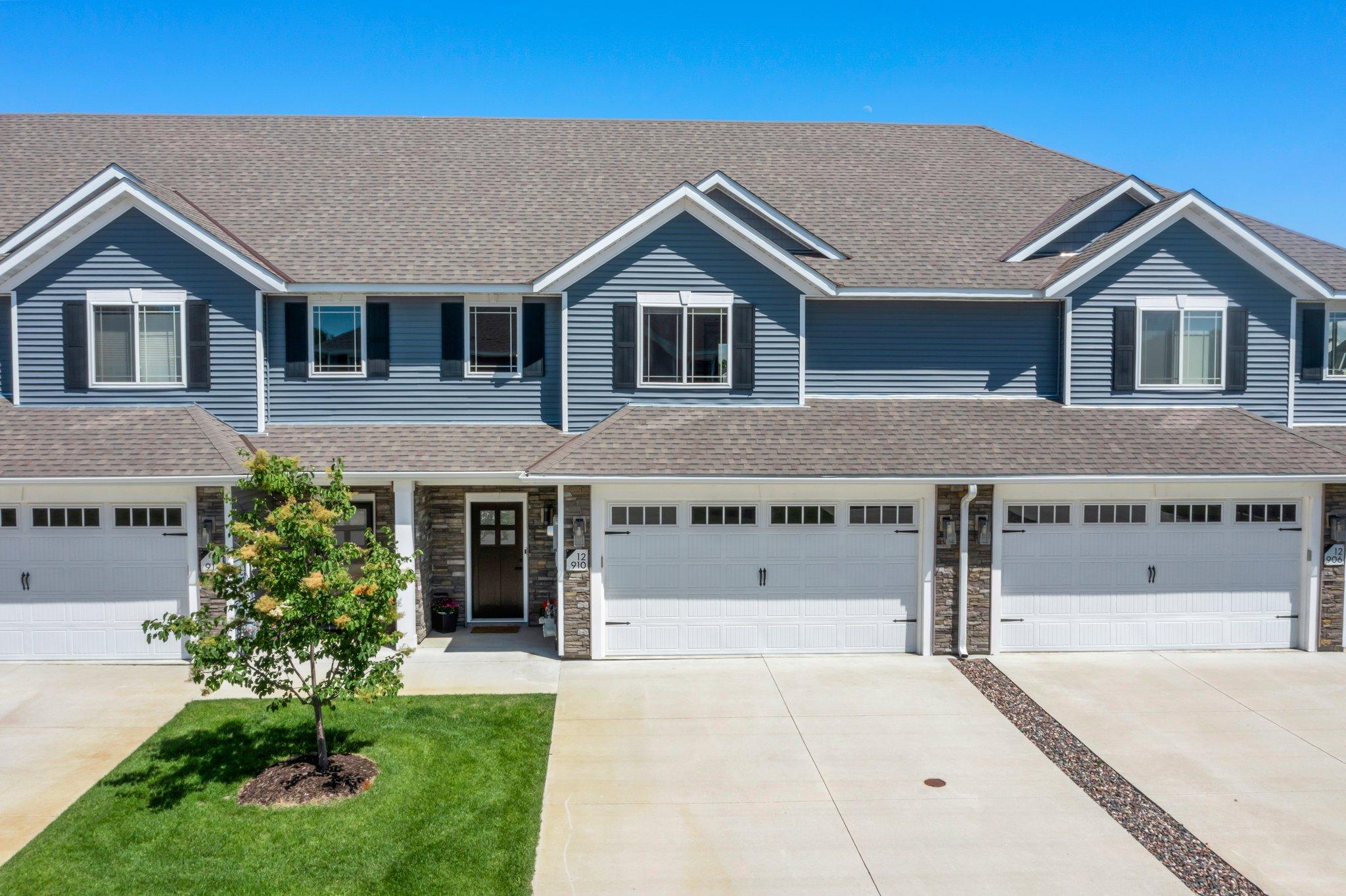 Welcome to this stunning 3-bedroom, 3-bathroom townhome nestled in the sought-after Brenly Meadows community. Built in 2020, this home features modern, custom finishes throughout and is ideally located in the heart of Rogers—just a short walk to Main Street, nearby parks, and scenic walking trails. Enjoy the convenience of being close to shopping, dining, and with easy access to Highway 94 for a seamless commute. As you step into the foyer, you're welcomed by soaring 18-foot ceilings, a striking modern chandelier, and stunning luxury plank flooring that flows seamlessly throughout the home. Solid wood doors throughout add to the quality and warmth of the interior. The kitchen is a chef’s dream, featuring sleek stainless steel appliances, granite countertops, and a spacious center island with breakfast bar seating and contemporary lighting. You'll find rich, solid wood maple cabinetry with soft-close doors and drawers, along with a classic subway tile backsplash that completes the modern yet inviting aesthetic. Just off the kitchen is the informal dining area—ideal for everyday meals—with direct access to the concrete patio. It's the perfect setup for indoor-outdoor entertaining while enjoying serene views of the scenic backyard pond. The main-level living room offers a warm and inviting atmosphere, featuring a gas-burning fireplace with a beautiful stone surround, a modern ceiling fan for added comfort, and a large window that fills the space with natural light. A conveniently located half bathroom is just steps away. The upper level features three bedrooms, including a spacious primary suite with elegant tray ceilings, a ceiling fan, and luxury plank flooring. The room is equipped with a dimmable light switch for added ambiance, as well as custom top-down blinds for privacy and light control. You'll also find a generous 7x6 walk-in closet and a private ¾ bathroom complete with a sleek walk-in shower, double vanity with granite countertops, and ample solid wood maple cabinetry for storage. Bedrooms two and three on the upper level are similar in size and style, each featuring luxury plank flooring, ceiling fans, dimmable light switches, spacious 5x5 walk-in closets, and custom top-down blinds. Just steps away is a shared full bathroom offering double sinks with granite countertops, solid wood cabinetry, and a tub/shower combo. Conveniently located next to the bathroom is the upper-level laundry room. The home also includes an attached two-car garage, along with a newer water softener and water treatment system. Enjoy low-maintenance living with exterior upkeep—lawn care and snow removal are all included. Don’t miss this stunning, turnkey home located in a fantastic area of Rogers!