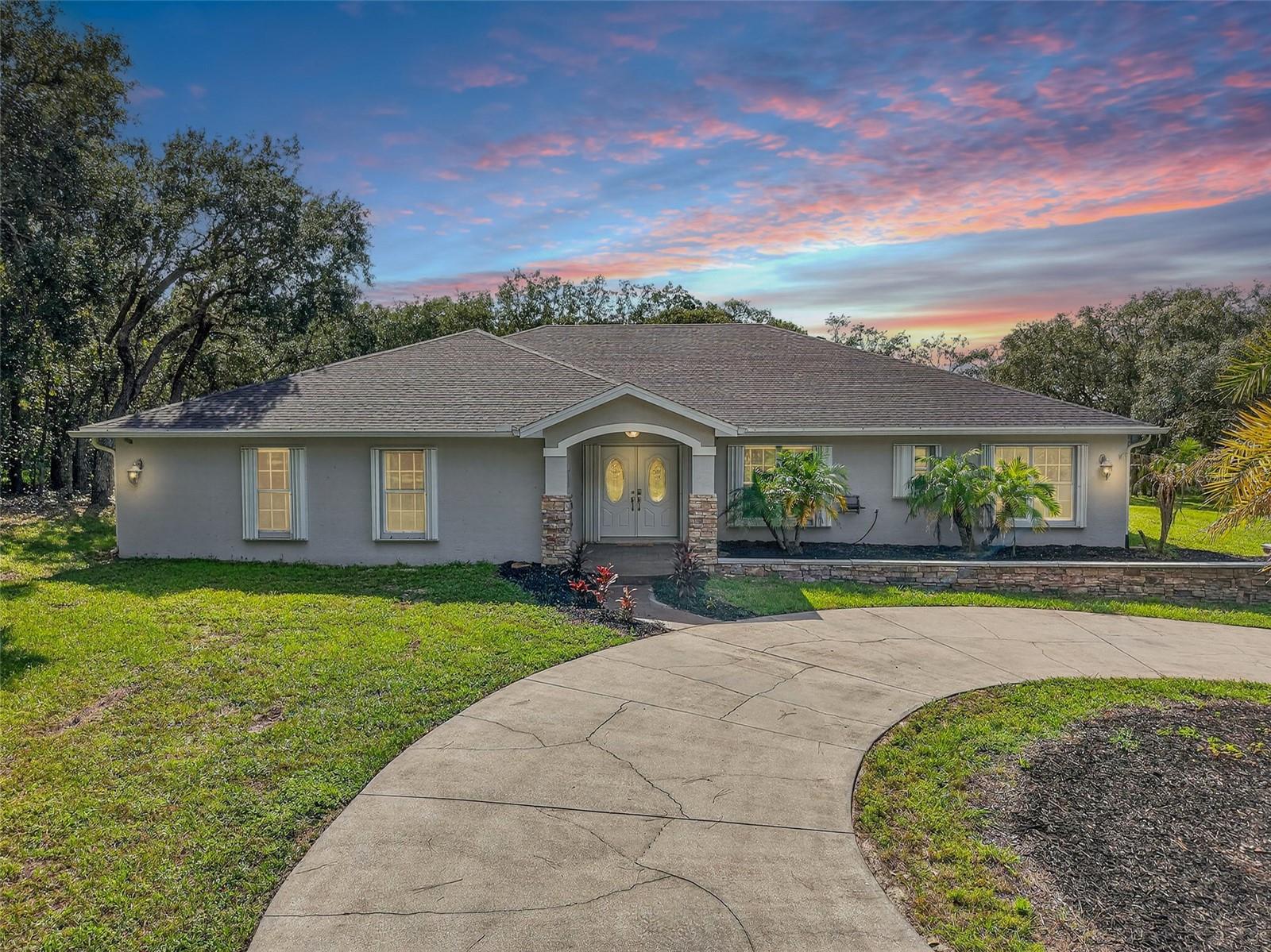 Nestled on OVER 11 ACRES in a NON FLOOD ZONE, this incredible 5-bedroom, 3-bathroom estate offers the perfect blend of comfort, space, and outdoor living. A BRAND-NEW ROOF was installed in August 2025 and TWO BRAND NEW WATER HEATERS installed September 2025, giving peace of mind from the start. Inside, you'll find a spacious layout with a large kitchen featuring stainless steel appliances, stone counter tops, a center island, and plenty of room for cooking and gathering. The inviting living area includes a cozy FIREPLACE and a flexible office or den space - ideal for working from home. The oversized primary suite boasts a WALK-IN CLOSET and a luxurious bathroom with a walk-in shower. Step outside to your private retreat, complete with a screened-in back porch, sparkling saltwater POOL, relaxing HOT TUB, and a full OUTDOOR KITCHEN and bar—perfect for entertaining year-round. A volleyball net adds to the fun, while the large covered parking pad that has RV hookup, outdoor storage shed, and circular driveway offer convenience and functionality. The extended, PAVED DRIVEWAY ensures an easy ride up to the house and a clean car! In addition to everything else, the property has multiple fenced in pastures for all future agriculture! An indoor utility and laundry room completes the package. Not only will you enjoy the spacious lot, but you’ll be nearby to the beach for those sunny days! This is a rare opportunity to enjoy true Florida living with room to roam—don’t miss it!