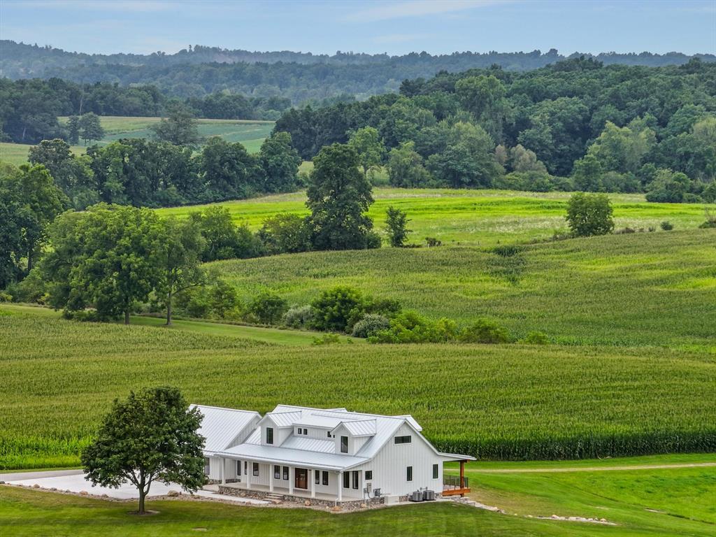 Refined country living - Welcome to a stunning, fully remodeled retreat set on 79.3 picturesque acres just 30 minutes from downtown Ann Arbor. This 3-bedroom, 5-bathroom home blends luxury, comfort and privacy, with thoughtful upgrades throughout. Enjoy 10'' wide-plank white oak floors, heated bathroom floors, and a gourmet kitchen outfitted with a Wolf range, Sub-zero refrigerator and Speed Queen laundry. A tankless water heater, full-home backup generator, new metal roof and Hardie Board siding ensure efficiency and peace of mind. The lower-level walkout includes a second full kitchen and opens to a spacious patio perfect for entertaining. Relax on the 50' x 8' covered front porch or grill and entertain on the 50' x 9' rear porch, equipped with gas and power hookups. A utility roomwith a dog wash sink adds everyday convenience. 

Outbuildings include a 30' x 70' three-stall shop, a 30' x 95' traditional barn (can you say event space?) and a 24' x 24' utility building. All three outbuildings have been newly sided in red cedar with new metal roofs so they all match and will last for many year to come. The land offers a beautiful mix of 60 acres of tillable ground, woods a small pond and a meandering creek.

This is more than a home - it's a lifestyle of elegance and serenity in the heart of Washtenaw County.