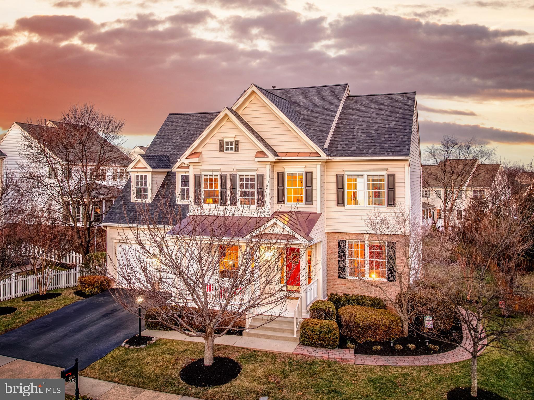 22876 Ashton Woods Drive sits in the heart of Brambleton, in a neighborhood where you can actually live without constantly getting in your car. Coffee, groceries, dinner reservations, the library, movies, the gym, even the farmers market and summer concerts are minutes away at Brambleton Town Center. On weekends, you’re not “finding something to do.” You’re choosing between trails, 4 pools (one heated), tennis under the lights, golf, Hal and Bernie Hanson Park, Legacy Park’s zip line and playgrounds, or a walk with the dog to the park down the street. Over 18 miles of paved trails connect it all. The HOA even covers Verizon FiOS internet and cable. It’s built for real life. Now let’s talk about the house. You walk into a true two-story foyer that feels open but not overwhelming. Formal living on one side. An oversized dining room with a bay window on the other. It’s the kind of layout that works when you’re hosting Thanksgiving but still feels easy on a random Tuesday night. The kitchen is the center of everything. A generous island with pendant lighting. 42-inch cabinets with more storage than you’ll probably ever fill. Gas cooktop, dual ovens, stainless appliances, stone countertops and backsplash. There’s a butler’s pantry connecting to the dining room, and a breakfast area that opens right into the family room. The fireplace anchors the space. It’s open, but not chaotic. You can cook, talk, supervise homework, and still feel connected. Need a main level bedroom or office? You have it. Tucked away but accessible, with a half bath nearby. Perfect for guests, in-laws, or a quiet work-from-home setup. Upstairs, the primary suite feels like a retreat. Hardwood floors, tray ceiling, a true sitting area, and a walk-in closet that actually works. The bath has dual vanities, a soaking tub, and a separate shower. One bedroom has its own en suite bath. Two others share a Jack and Jill. Everyone gets space. No one feels like they drew the short straw. The lower level is where this house really stretches out. Nine-foot ceilings keep it from feeling like a basement. There’s a huge rec room with a built-in home theater system, a wet bar for game days, a large flex space, a full bedroom and bath, and a walk-up exit to the backyard. It’s set up for movie nights, teenagers, guests, or multigenerational living without anyone stepping on each other. And then there’s the backyard. Flat. Huge. Fully fenced. A large stone and paver patio already in place. Irrigation system installed. This is not the “postage stamp” yard people complain about. This is the yard where you host graduation parties, set up a soccer goal, or just sit outside after work and decompress. 4400 finished square feet across three levels. Nine-foot ceilings. Crown molding. Recessed lighting throughout. Two-zone HVAC. Roof replaced in 2024. EV charger and subpanel installed in 2018. Hot water heater 2019. Furnace 2014. The heavy lifting has been done. Location matters here. You’re within five miles of the Ashburn Silver Line Metro. Easy access to the Dulles Greenway, Route 50, Route 7, Route 28, Route 15. Under nine miles to Dulles Airport. If you commute, this works. If you travel, this works. Don't forget about our highly rated school pyramid either! This isn’t just six bedrooms and four and a half baths. It’s a house that adapts as life changes. Young kids, teenagers, live-in family, remote work, hosting holidays, backyard parties. It handles all of it. Brambleton isn’t just where you live. It’s where your routine gets easier. And this home gives you the space to enjoy it.