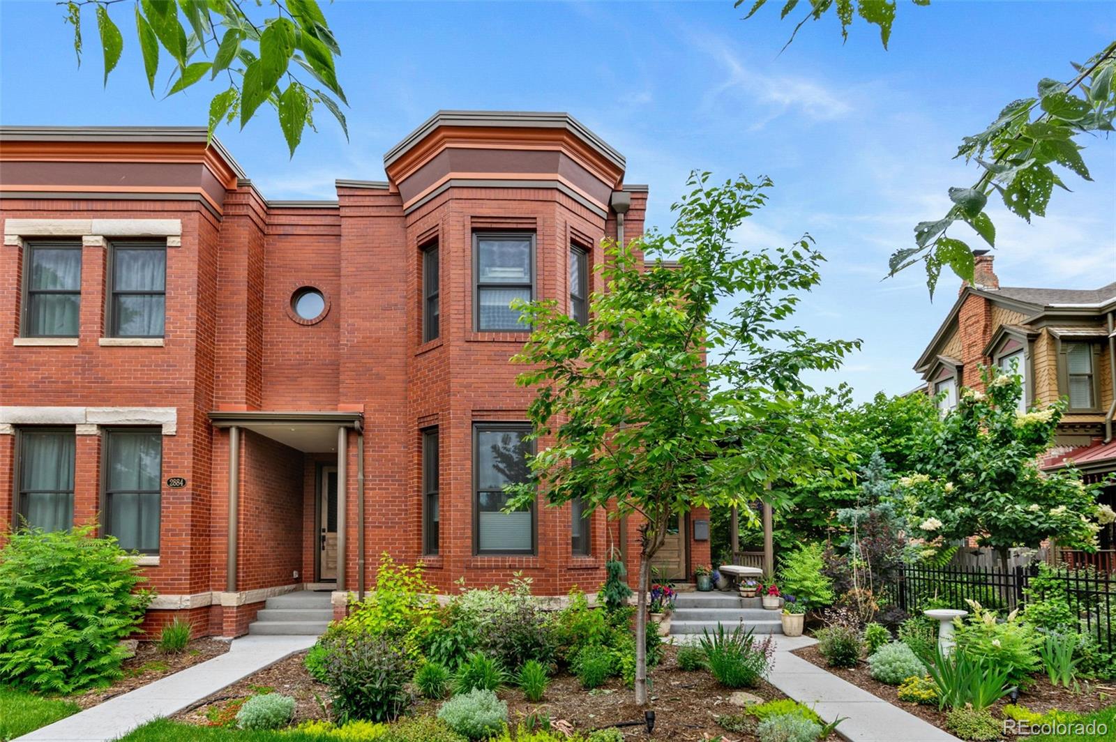 Welcome to this thoughtfully designed and elegantly appointed end-unit townhome located in the heart of historic Curtis Park. Constructed in 2018, this four-bedroom, four-bathroom residence harmoniously combines the charm of Curtis Street with its brick construction, covered front porch, and two-story bay windows, while simultaneously embracing the contemporary amenities sought by discerning buyers.  The open floor plan, high ceilings, and three-story grand staircase that floods the basement with natural light create a spacious and inviting space. Upon entering the foyer, the main floor features an office, gourmet kitchen, dining area, and a great room. The chef-inspired kitchen boasts an expansive eat-in island, quartz countertops, stainless steel appliances, a six-burner gas stove with a custom Zephyr hood, walk-in California Closet designed butler pantry, and overlooks the dining area and great room with a gas fireplace.  Ascending the light-filled staircase to the upper level, the primary en-suite bedroom offers a walk-in closet, electronically shaded skylight, and an attached five-piece bath with a soaking tub and large shower. It is conveniently separated from the other two bedrooms by a laundry room with task sink and a full bath.  The fully-finished spacious lower level features a living room, office nooks, a fitness area with a children’s climbing wall and an oversized additional bedroom with a walk-in closet, egress, full bath and additional storage.  The meticulously maintained landscaped grounds include an outdoor dining area, built-in Blaze gas grill, a paver patio with pergola, a smart sprinkler system with drip lines and architectural lighting.  The oversized two-car detached garage (22x22) with custom storage solutions is located off a recently paved alley.  This well-constructed home is situated one block from Curtis Park, three blocks from RiNo’s Larimer Street, and four blocks from Five Point’s Welton Street corridor.