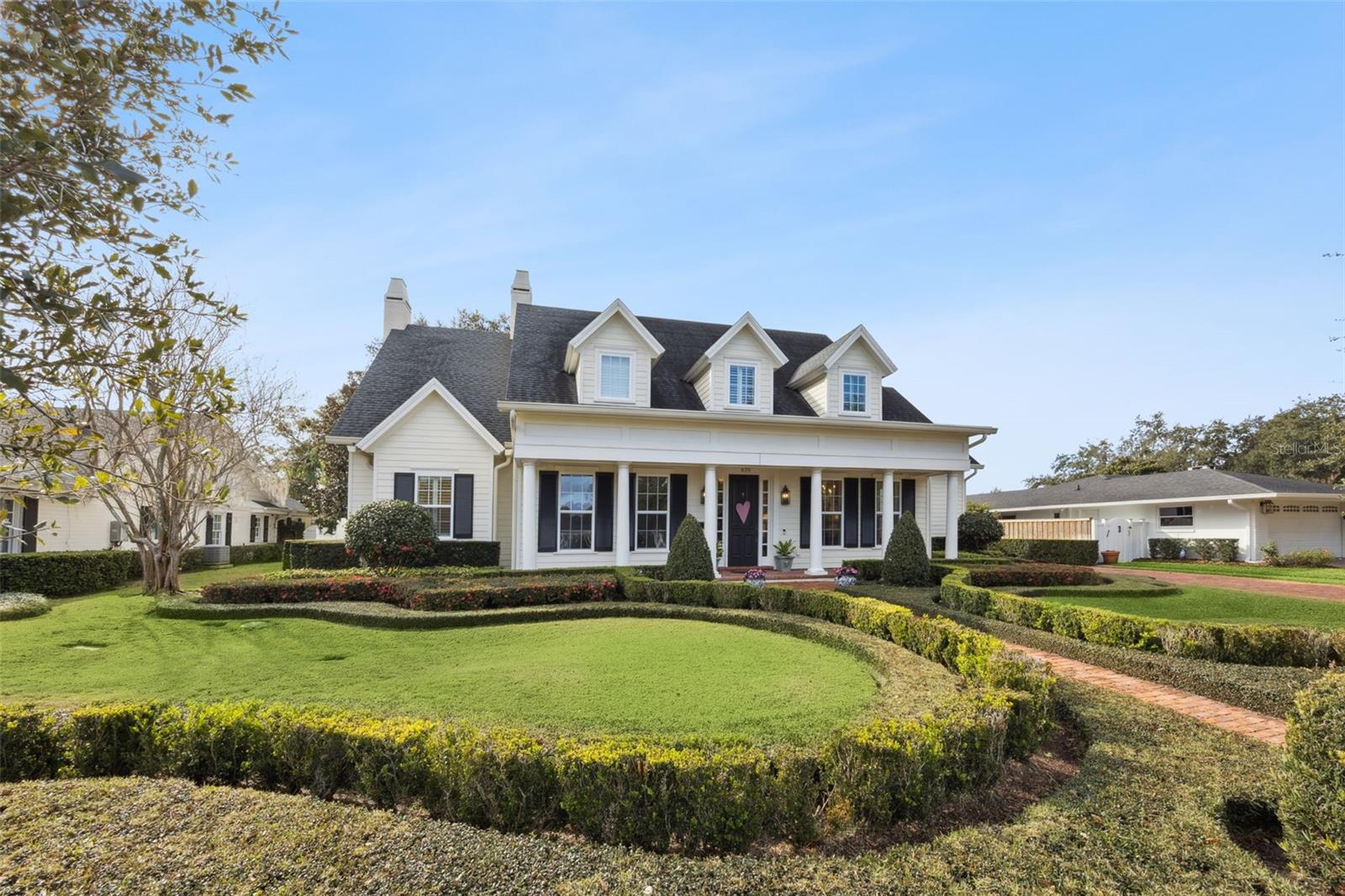 This stunning custom residence built by respected Winter Park Builder Charles Clayton blends classic elegance with refined modern comfort, offering seamless indoor–outdoor living and impeccable craftsmanship throughout. From the manicured lawn and stately traditional exterior to the welcoming front porch with old Detroit brick, the home’s curb appeal sets a tone of understated luxury, all wrapped in an elegant exterior. A foyer with extensive custom molding immediately captures attention, with sightlines extending to the private backyard and pool which creates a natural flow between interior living spaces and the outdoor retreat. Flanking the foyer, a richly detailed private study features custom millwork and a built-in bookcase, while the formal dining room provides an elegant space for entertaining. Expansive family room/dining area offers extensive molding, a gas fireplace, surround sound, and a wall of French doors which open to a covered Detroit Brick porch, creating a natural flow between interior living spaces and the outdoor retreat including a porch and pool. The space easily accommodates a large casual dining area and opens seamlessly to the kitchen. The light-filled chef’s kitchen showcases extensive marble surfaces, a Sub-Zero refrigerator, large farmhouse sink, and an open layout ideal for gathering. The main-level primary suite is a private retreat with direct porch access, dual walk-in closets. The primary bath features marble finishes, a glass-enclosed shower, pedestal soaking tub, and dual vanities. A spacious mudroom, large laundry room, and pantry area sit just off the kitchen, complete with a half bath and convenient access to the garage and porch. The two-car garage includes additional storage, complemented by a brick driveway. Upstairs, a central stair hall opens to an upstairs Family/Kid’s Gathering/Game Area. Bedroom 2 functions as a second primary-style suite, while bedroom 3 is a private suite with its own sitting area. Bedrooms 4 and 5 share a Jack-and-Jill bath, providing flexible space for family or guests. There is an upstairs storage room. Outdoor open pool with living is equally impressive. This exceptional home offers the ideal balance of architectural character, luxury finishes, engineered wood floor  and a floor plan designed for comfort, privacy, and unforgettable gatherings.