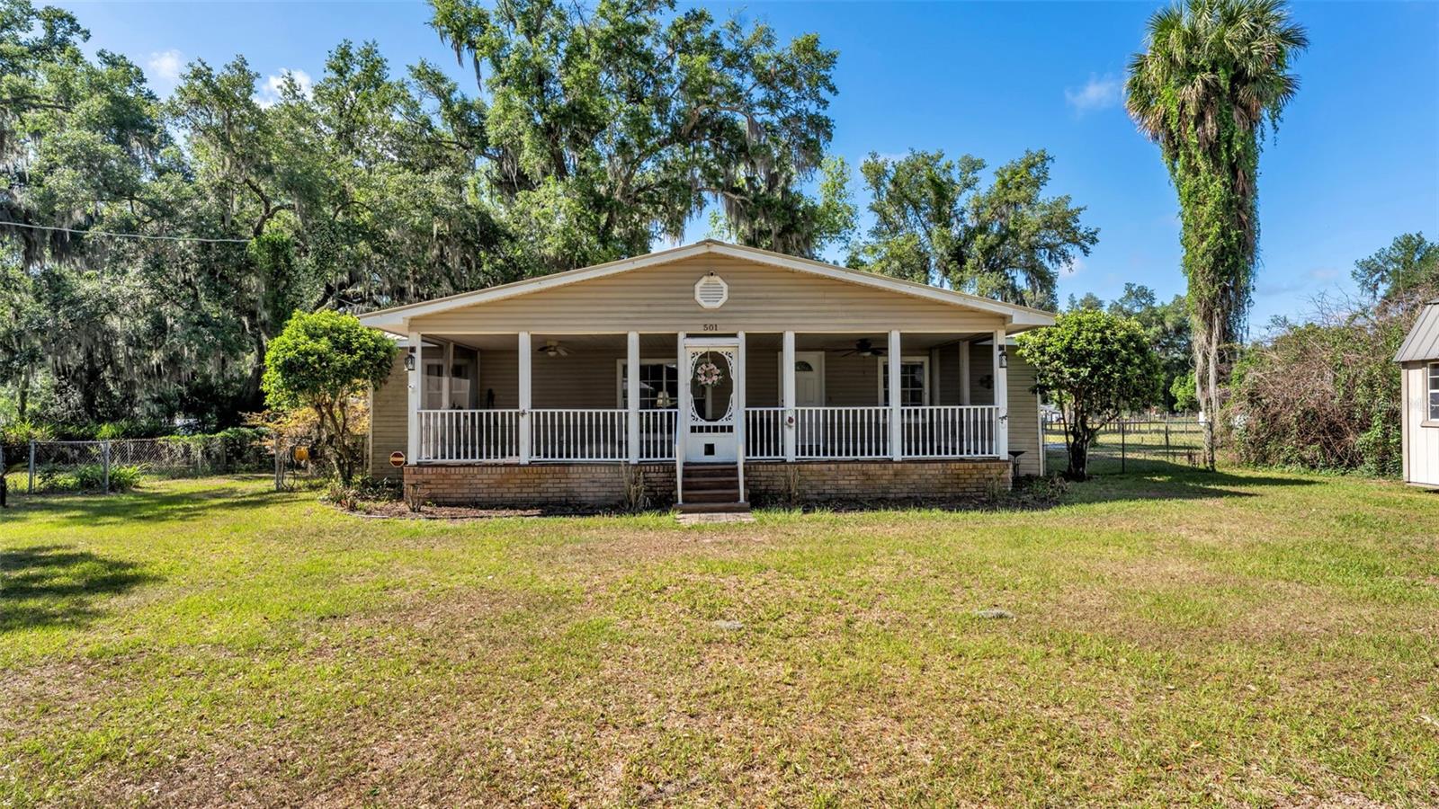 Welcome to 501 Swilley Rd in Plant City, a peaceful 3 bedroom, 2 bath home situated on .53 acres with room to enjoy the outdoors. From the moment you arrive, the large screened front porch sets the tone, offering the perfect place to relax with your morning coffee or tea while taking in the quiet setting. Step inside to a spacious living area featuring a beautiful wood-burning fireplace that creates a warm and inviting focal point. The layout flows into the dining area and kitchen, creating a comfortable setup for everyday living and entertaining.The bedrooms are located on one side of the home, offering a functional layout with the main living spaces on the opposite side. The primary bathroom also includes the laundry area for added convenience, and the additional bedrooms are generously sized. Recent updates include new LVP flooring throughout the home, and all appliances will stay. The property also features a septic system with a new drain field completed a few years ago, a metal roof, a rear deck, a carport, and two sheds that will remain with the property, including one with electric already ran to it. With its peaceful setting, functional layout, outdoor space, and extra storage, this Plant City property offers comfort, charm, and plenty of possibilities.