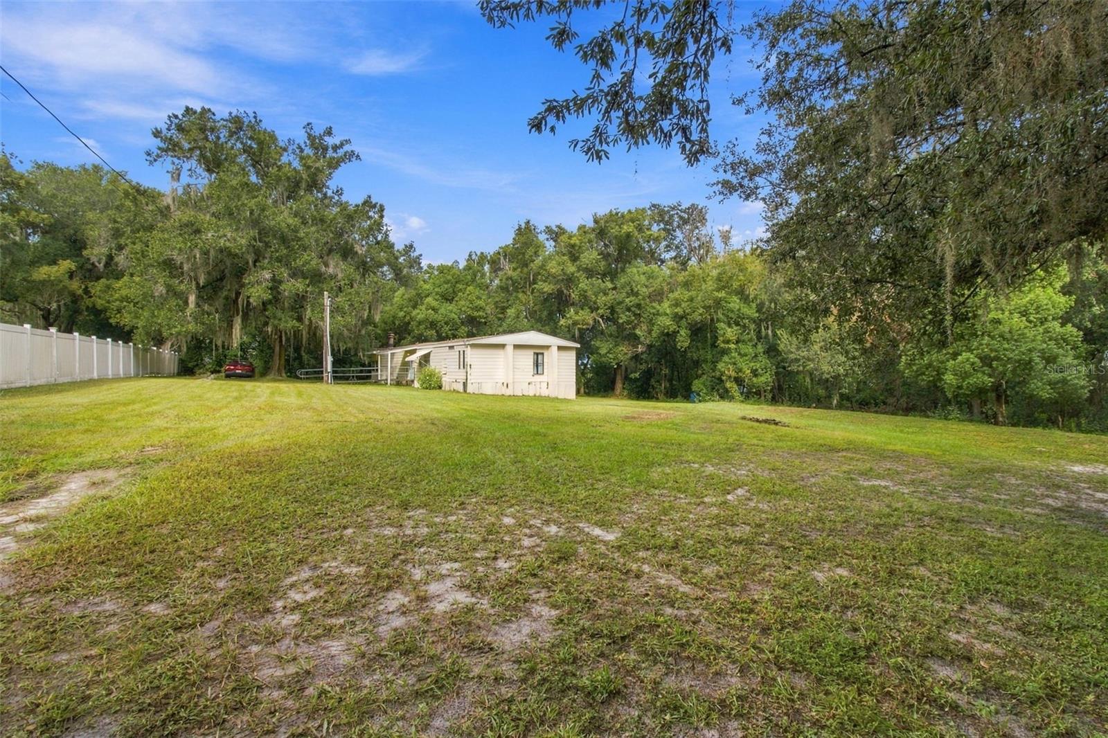 RARE 20 ACRE PRIVATE RETREAT IN ZEPHYRHILLS! Escape the crowds and enjoy the peace, privacy and natural beauty of owning approximately 20 acres in a rapidly growing area. Approximately 1.5 acres surrounding the existing manufactured home offer a dry, improved homesite with well, electric and septic tank already in place. The remaining acreage consists primarily of wetlands and marsh, providing a natural setting and a rare sense of space and seclusion.  The property borders portions of Lake Elam and Lake Holder, adding to its scenic appeal and creating a peaceful backdrop for enjoying Florida's wildlife and outdoors. Imagine having your own private retreat with substantial acreage separating you from surrounding homes a welcome opportunity to enjoy privacy, tranquility and room to breathe.A manufactured home remains on the property but is in disrepair and is not considered habitable. It will convey in its current condition. Buyer to perform due diligence regarding wetlands, land use, building possibilities, existing utilities and septic system, access, and any future improvements.