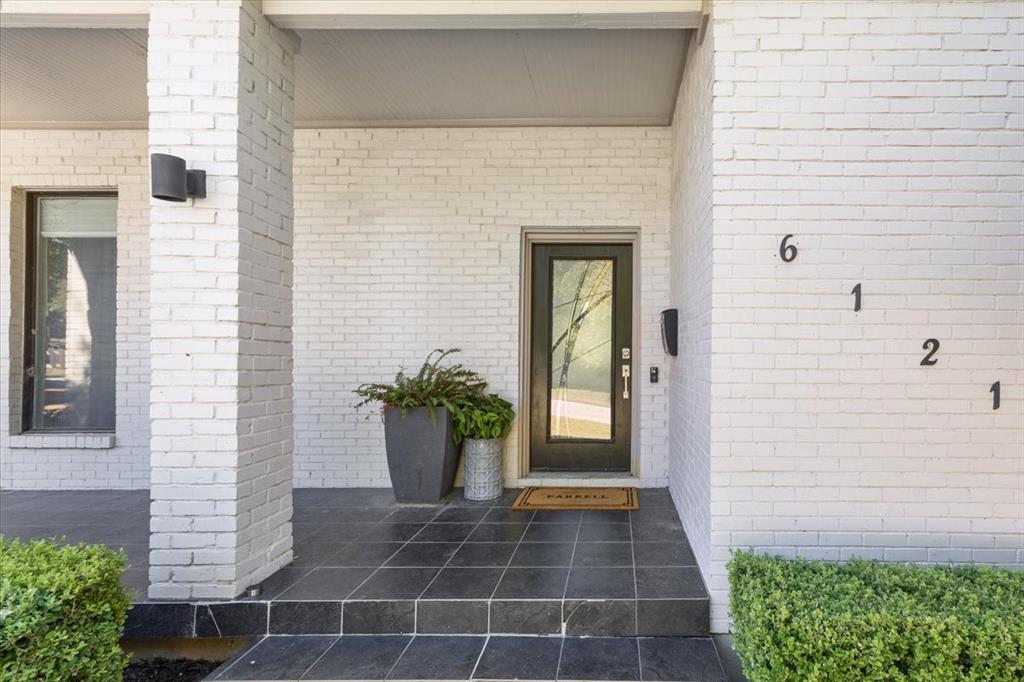 Tucked on a quiet, tree-lined street near Ridglea Country Club, this updated home combines timeless curb appeal with a modern, comfortable layout. The white brick exterior and mature landscaping lead to bright interiors with hardwood floors and abundant natural light. An open living area centers around a sleek fireplace and flows easily into the dining space and updated kitchen, which features soft gray cabinetry, stainless appliances, generous prep areas, and a large island plus additional peninsula for breakfast bar seating. The spacious primary suite offers a peaceful retreat with a walk-in closet and a spa-inspired bath featuring a soaking tub, glass shower, and dual vanity. Outside, layered patios shaded by mature trees create a private, inviting setting for entertaining or relaxing. A detached two-car garage completes the property.