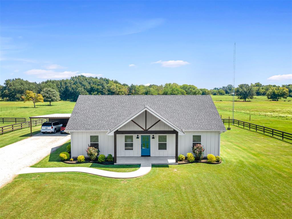 Attractive 3 bedroom, 2 bath home comes with landscaping, Smart Siding, 2-car carport, and a spacious 4 acres! Located on a quiet County Road southeast of Sulphur Springs, enjoy the panaromic views from the vaulted porches. Step inside an impressive entrance with wood-ceilings and vaulted open floor plan. A vent-less gas log fireplace will provide lots of cozy ambience on cold, brisk nights. Bring your recipes to a kitchen with marble countertops, 2 ovens, island with breakfast bar seating, farmhouse sink, tile backsplash, stainless steel appliances, and door to covered back porch. Durable porcelain wood-looking floors presents a beautiful flow throughout the living, dining, laundry room, and bathrooms. The primary bedroom comes with a vaulted ceiling, walk-in closet, double sinks, and a walk-in shower with subway tile. Split from the primary bedroom, the guest bedrooms share a full bathroom with subway tile in the shower. A laundry room and mudroom are located near the back entrance. Additional perks include recessed lights, spray-foam insulation in attic, marble countertops in the bathrooms, ceiling fans, carport storage area, outdoor fire pit, gutters, and French drains. Work from home with HIGH-SPEED INTERNET while relishing this spectacular country setting, only minutes to town!