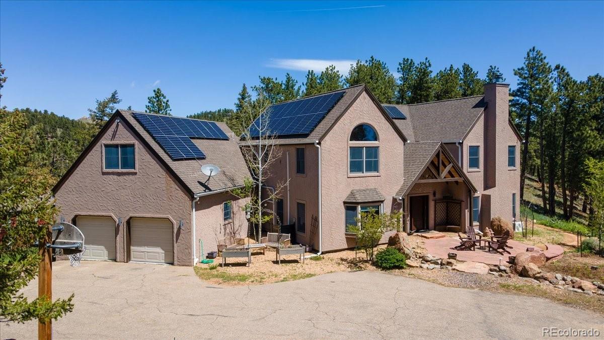 Commanding panoramic mountain and city views from atop 14+ private acres, this extraordinary gated estate offers a rare opportunity to own a true mountain sanctuary just 15 minutes from downtown Boulder. Located within the exclusive Reed Ranch community, this timeless post-and-beam residence blends refined mountain elegance with unmatched privacy. Walls of windows and soaring ceilings flood the home with natural light while perfectly framing breathtaking vistas in every direction — from golden sunrises over the foothills to the sparkling city lights of Boulder below. Designed for elevated living and exceptional entertaining, the main level showcases a gourmet chef’s kitchen featuring slab granite countertops, stainless steel appliances, gas cooktop, oversized island with seating, and designer pendant lighting. The adjacent great room offers dramatic fireplace and seamlessly flowing into formal living and dining spaces ideal for hosting intimate gatherings or large-scale celebrations. Upstairs, vaulted ceilings continue throughout the private quarters. The luxurious primary suite offers a spa-inspired five-piece bath, a serene retreat at the end of the day. Additional bedrooms and an open loft provide flexible accommodation for family and guests. Separate guest suite above the garage includes its own living area, bedroom, & bath, perfect for extended stays, multigenerational living, or home office retreat. Step outside into your own private Colorado resort. Expansive patios, a hot tub beneath endless skies, and a secluded hilltop overlook create an unparalleled setting for relaxation and reflection. With over 14 acres of pristine land surrounding you, the property offers extraordinary seclusion without sacrificing convenience. Whether as a full-time residence or an exceptional second home in the mountains, this estate delivers the ultimate Boulder lifestyle, privacy, luxury, & effortless access to world-class dining, culture, and outdoor recreation just minutes away.