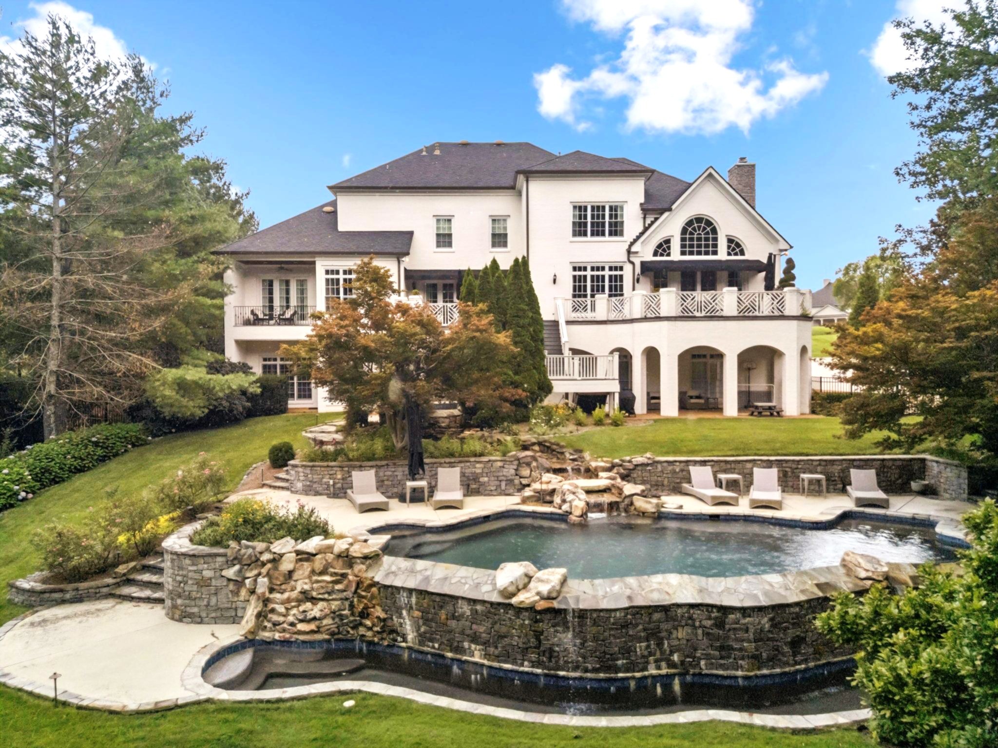 Every detail of this home has been thoughtfully designed with sophistication and comfort in mind. This stunning luxury estate sits in a private gated community just minutes from Cool Springs, Green Hills, and Richland Country Club. Designed for ultimate comfort and unforgettable gatherings, this 5-bedroom, 5 full bath, 5 half bath masterpiece features exquisite details, natural light, and open-concept living throughout. Designer Light Fixtures. Hunter Douglass Automatic Blinds in Primary Bedroom & Closet, Dining Room, Office, and Entryway. Schumacher Wallpaper. The gourmet kitchen boasts a SubZero refrigerator, GE Monogram Appliances, two dishwashers, and seamless flow into the den and breakfast & dining areas—perfect for hosting. The main-level primary suite is a luxurious retreat featuring a boutique-style closet, two water closets, towel warming drawer, and a heated marble bathroom floor. The second level hosts 2 Bedrooms with en suite baths and a fabulous theater room/rec room. The lower-level walkout basement is so spacious, filled with windows, a full second kitchen near the elevator for convenience, a large bonus room, bedroom, and full bathroom. Step outside to a showstopping resort-style backyard with saltwater infinity pool, waterfalls, large spa, two covered patios, lush landscaping, and space to build your dream outdoor kitchen. New Pool Equipment and Pool Resurfacing in 2022. Additional highlights: 3-stop elevator, Retractable Dining Room Chandelier, 4 fireplaces, safe room, 2 Laundry Rooms, circular driveway, massive attic space, and a spacious 4-car garage. This home combines function, luxury, and warmth in one unforgettable package!