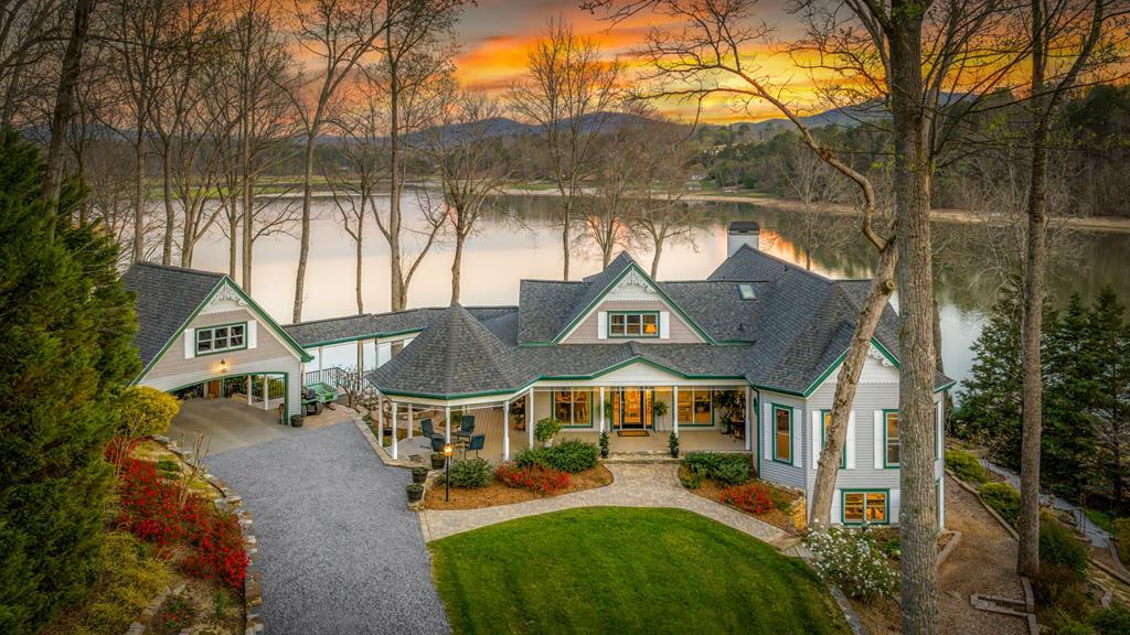 Perched on over 5 acres of picturesque lakefront with phenomenal mountain and water views, 216 Burnell Lane is a truly one-of-a-kind retreat blending historic charm with thoughtful modern updates. Originally built in 1920 and extensively renovated and expanded in 1998, this distinctive property offers character, space, and a setting that is simply unforgettable. Designed to embrace its natural surroundings, the home features multiple decks, inviting covered porches, and a screened porch—perfect for year-round enjoyment of the peaceful waterfront landscape. A charming gazebo and a gentle paver brick walkway lead you to the lake's edge, creating an ideal setting for relaxing mornings and effortless entertaining. Inside, warmth and character abound with a stunning stone fireplace anchoring the main living space, while large windows fill the home with natural light and frame the incredible views. The spacious layout includes 4 bedrooms and 4 baths, offering flexibility for family and guests alike. The primary suite is designed for comfort, featuring separate vanities and a serene atmosphere. Quality craftsmanship and thoughtful upgrades are evident throughout, including double-pane Pella ProLine windows with vinyl-clad exteriors and wood interiors—combining durability with timeless appeal. The home is equipped with two dual-fuel HVAC systems (gas and heat pump), ensuring efficient and comfortable living in every season. Rich in history, beautifully updated, and set on a rare acreage with lake frontage, this exceptional property offers a lifestyle that is both private and inviting—where every detail is designed to take full advantage of its breathtaking surroundings.