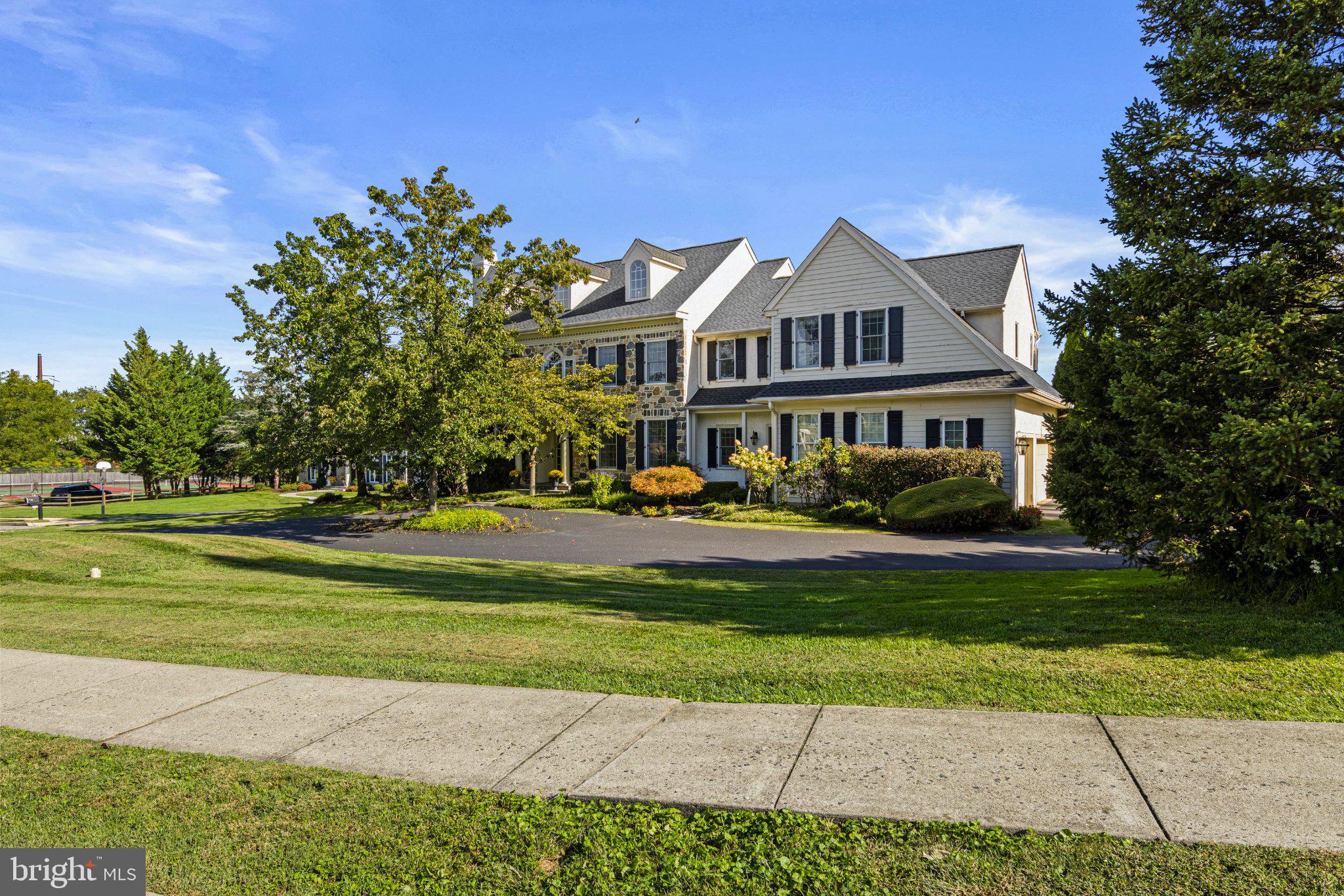 Welcome to 210 Quisset Lane, a beautiful stone Colonial set at the end of a quiet cul-de-sac in the sought-after Whitegate community of Wayne. With timeless appeal, a wonderful floor plan, 5-6 spacious bedrooms, an exceptional finished lower level, and a spectacular private backyard with a pool, this home offers an ideal combination of comfortable everyday living and exceptional entertaining space.A welcoming center hall with a turned staircase introduces the light-filled first floor, featuring hardwood floors, beautiful millwork, recessed lighting and freshly painted interiors. The formal living room includes a wood-burning fireplace and custom mantel, while the dining room is accented by wainscoting and crown molding. A bright study overlooking the rear yard provides a comfortable and private space for working from home.The heart of the home is the open kitchen, breakfast room and dramatic two-story family room. The gourmet kitchen features granite countertops, a large center island with seating, stone backsplash and stainless steel appliances including a Sub-Zero refrigerator, Wolf gas cooktop, Bosch dishwasher and double oven and built in microwave. The adjoining breakfast room opens to the rear terrace, while the impressive family room features a soaring two-story ceiling, stone wood-burning fireplace, built-in cabinetry and a dramatic wall of windows overlooking the pool and backyard. A convenient bar area with a wine refrigerator and sink makes entertaining easy. A large mudroom with built-in cabinetry and lockers, second powder room, back staircase and access to the three-car garage complete the first floor.Upstairs, the spacious primary suite features hardwood floors, a tray ceiling, two large walk-in closets, a private office and an expansive bath with dual vanities, soaking tub and separate shower. Four additional generously sized bedrooms, two additional full baths and a large second-floor laundry room provide plenty of space and flexibility.The finished lower level offers even more room to gather, play and entertain, with multiple recreation and seating areas, built-in bookcases, a charming built-in playhouse, full bath and an additional room that can serve as a guest bedroom, exercise room or home office. Movie nights are especially fun in the dedicated theater room with theater seating and equipment included, and a built-in bar with beverage refrigerator completes the space.Outside is truly something special. The expansive flagstone patio, raised dining area, oversized heated pool and hot tub create a private backyard retreat surrounded by mature trees and landscaping. The fenced yard offers plenty of room for recreation and entertaining while providing wonderful privacy.Additional features include a whole-house generator, Sonos music system, garage EV charger, outdoor lighting and irrigation system. Whitegate residents also enjoy convenient access to the neighborhood park, playground and tennis courts. All of this in a desirable Wayne location convenient to shopping, dining, major roadways and everything the Main Line has to offer. 210 Quisset Lane is a home designed to be enjoyed—inside and out.