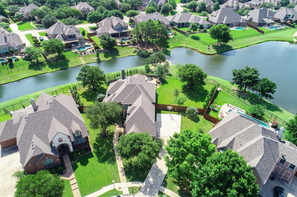 This is an exceptionally rare opportunity to own one of Keller's most beautifully landscaped properties! This gorgeous home is nestled on a PREMIER .43-acre, cul-de-sac lot with SPECTACULAR PROFESSIONAL LANDSCAPE AND SERENE LAKE VIEWS in Harmonson Farms. As one is ushered into the home through an impressive front door, they will find gracious windows, tall ceilings and designer touches throughout every room. The functional floor plan boasts an elegant dining room, a formal living area-study, an oversized family room showcased by a traditional stone fireplace, a custom built-in entertainment center and a wall of windows allowing for serene views of the backyard oasis; a remodeled kitchen complete with an oversized center island-breakfast bar, 5-burner gas stove-top, dual ovens, upgraded cabinetry, Butler's pantry and a charming breakfast nook before windows. Nestled away from the traffic areas of the home, the primary suite has a sitting area before bay windows and a spa-like bathroom featuring dual sinks, jetted tub and a walk-in shower. In addition, the first-floor hosts a secluded guest suite with full bath and utility area. Upstairs, one will find an entertaining game room area with loft and a walk-out balcony, four nicely-appointed bedrooms with a media room option and two full bathrooms. Key amenities include fresh exterior paint, a plethora of windows with plantation shutters, engineered hardwoods, updated carpet, a grand staircase with wrought iron spindles, modern fixtures, custom built-ins, extensive storage and a three-car garage with epoxy flooring. Perfect for alfresco relaxation all year long, the backyard is the PERFECT ENTERTAINING OASIS with a covered patio overlooking beautiful lake views on all three sides, magazine-worthy landscaping, a sparkling pool-spa and plenty of room for play. This home feeds the award-winning Keller ISD and is ideally located just a short commute to DFW International Airport, upscale shopping and local eateries.