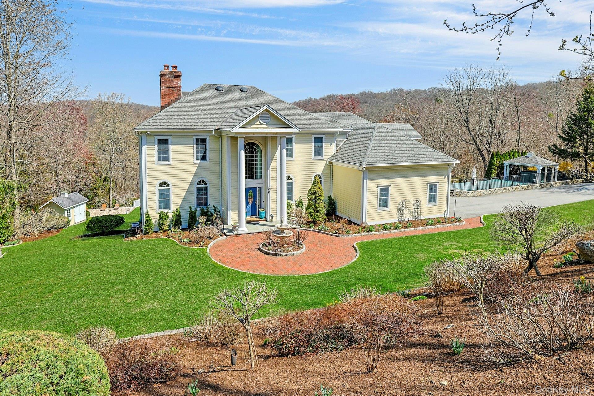 Welcome to 350 Wooded Hill Court. A grand, young Colonial offering resort-style living in Chappaqua, sited on 2.9 acres. Discover the perfect blend of luxury, lifestyle, and location in this exceptional 4-bedroom, 4.5-bath set on a private cul-de-sac just minutes from town, schools, shopping, and Metro-North. Built with exquisite craftsmanship by one of Chappaqua’s most reputable builders, this home showcases superior quality, timeless detailing, and an open floor plan ideal for modern living. A striking two-story entry foyer sets the tone for the sun-filled interior, featuring Brazilian Cherry floors throughout, elegant millwork, and expansive windows framing views of the meticulously landscaped grounds. The gourmet chef’s kitchen offers top-of-the-line appliances, custom cabinetry, and seamless flow into the family room and sunroom, perfect for everyday living and entertaining. Upstairs, the luxury primary suite feels like a private retreat with a massive custom walk-in closet/dressing room complete with office space and a spa-inspired bath. Three additional spacious bedrooms and beautifully appointed baths complete the second floor. The lower level is an entertainer’s dream, featuring a state-of-the-art home theater, full wet bar, recreation space, and direct access to the yard. Step outside to your own private oasis. A breathtaking Gunite infinity-edge pool, charming gazebo, stone patios, stone walls, and specimen trees create a resort-like setting. Whether hosting summer gatherings or enjoying peaceful mornings outdoors, this property delivers unmatched indoor-outdoor living. Additional highlights in • Full-house generator • 3-car attached garage with 2 charging stations• Newer roof. Award winning Yorktown Schools.