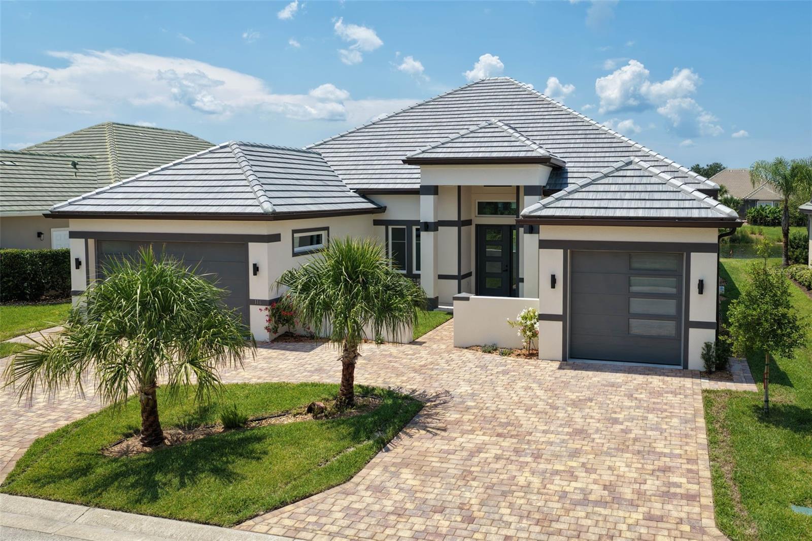 Every element of this exceptional new residence reflects a level of quality and craftsmanship rarely found in today’s new construction. From the energy-efficient Saxony tile roof to the exquisite baseboard molding, no upgrade option was left unturned. This brand-new custom home in the gated Tidelands community is a true showcase of thoughtful design, elevated finishes, and meticulous attention to detail.A grand courtyard entrance, circular paver driveway, dual garages offering 3 bays, and striking architectural details create an impressive first impression. Inside, beautiful porcelain tile flooring flows throughout a thoughtfully designed floor plan created for effortless everyday living and seamless indoor-outdoor entertaining.The chef’s kitchen is nothing short of spectacular, featuring a massive waterfall quartz island, extensive custom cabinetry, a hidden walk-in pantry, top-of-the-line appliances, double ovens, and a convenient Cosmo microwave drawer. The private dining room provides an elegant setting for entertaining, while the light-filled living room showcases an electric fireplace with stunning fluted accents and a wall of windows framing beautiful water views.Glass doors open to a covered paver patio designed for outdoor enjoyment, complete with an outdoor sink and cabinetry for effortless entertaining. The water view creates a vibe that feels as luxurious as the interior.The primary suite is a private retreat, featuring his-and-hers walk-in closets with custom built-in closet systems and a luxurious ensuite bath. Dual vanities, a beautiful soaking tub, Toto toilets, and an oversized custom-tiled rain shower with glass enclosure create a true spa-like experience. Three generously sized guest bedrooms and beautifully appointed bathrooms carry the same exceptional level of quality and craftsmanship throughout. A versatile flex room/den provides additional space for an office, media room, or personal retreat. Every closet throughout the home features custom built-in organization systems, while the spacious laundry room includes a convenient laundry tub. The three-car garage offers abundant storage and impressive 8-foot garage door heights, providing plenty of room for taller vehicles.This is more than a new construction home—it is a meticulously crafted coastal retreat where luxury, functionality, and craftsmanship come together beautifully.Tidelands enhances the lifestyle with a resort-inspired setting surrounded by nature, including a full mile of Intracoastal walking paths, a picturesque gazebo, two sparkling pools, a fitness center, and more. Located in a desirable gated community, this exceptional residence offers the opportunity to enjoy refined coastal living in one of Palm Coast’s sought-after waterfront communities. (CHECK OUT the WALKTHROUGH VIDEO & FLOOR PLAN)
