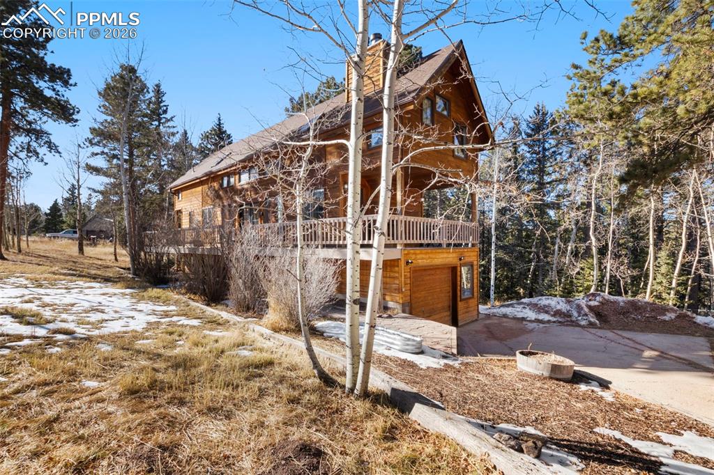 This charming residence captures the nostalgic essence of a Colorado cabin, making it an excellent choice for both a primary residence or a weekend escape. Nestled on over 2 acres, the property is fully fenced and features a solar-powered gate, ensuring easy access. Surrounded by picturesque aspen and pine trees on the entire property, it provides a tranquil setting with ample privacy, perfect for relaxing by the wood-burning fireplace on the newly painted wrap-around deck or hosting a social gathering around the fire pit at the property's center, a picturesque spot.Inside, the home showcases a stunning wood-vaulted ceiling that enhances the spacious and welcoming atmosphere. The updated kitchen features beautiful hickory cabinets, a gas range, stainless steel appliances, and solid stone countertops, seamlessly flowing into the family room and dining area, which is highlighted by another inviting wood-burning fireplace.The upper level includes brand new carpeting and two inviting bedrooms that provide cozy retreats, complemented by two lofts that overlook the main living space. The basement offers a spacious recreation room and an additional bedroom with a walkout. The home is further equipped with several large storage closets and a heated garage, which includes a workbench and additional storage options.At the rear of the home, a stamped concrete patio awaits, featuring a hot tub that offers breathtaking views of the surrounding landscape. Among other notable features are a new Class 4 roof, solid wood doors throughout, and wood-encased windows. This property truly offers the finest in Colorado living.