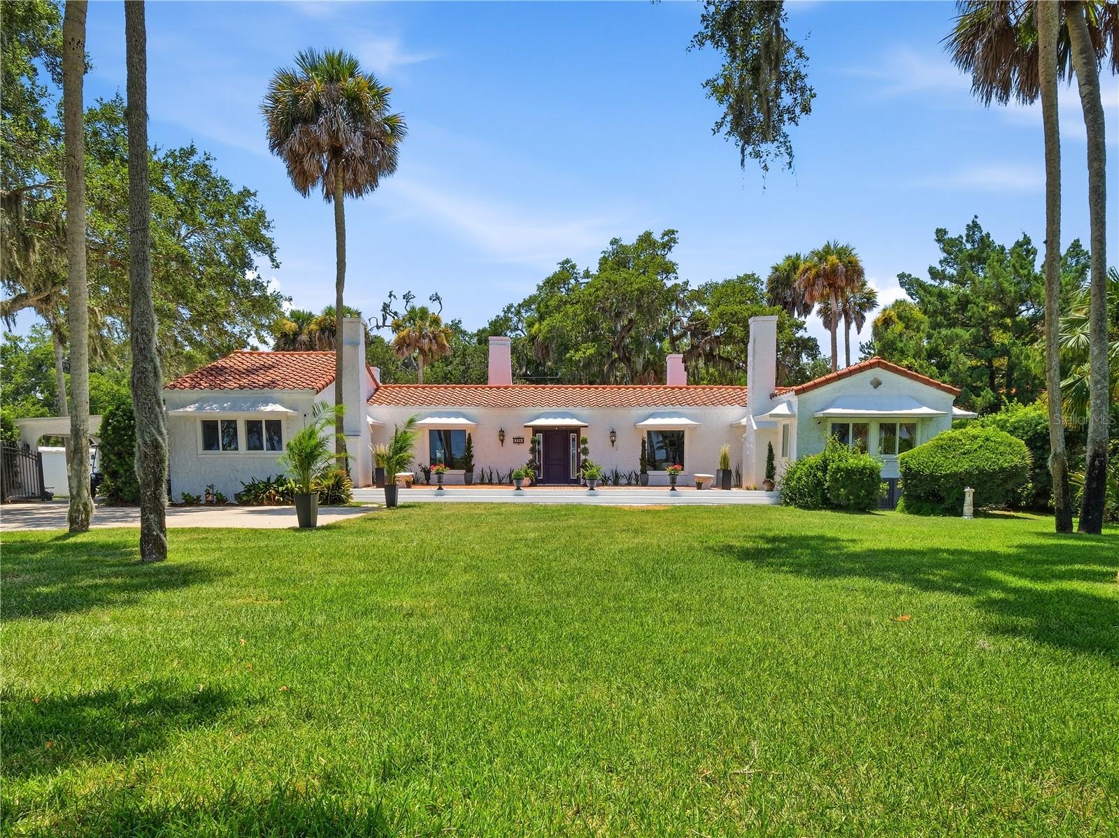 Historic, half-acre estate set along one of New Smyrna Beach's most treasured stretches of waterfront.  Sitting high, beneath a canopy of mature trees, this elevated, landmark property offers direct access to the Intracoastal Waterway and is just a short walk from downtown Canal Street. Known as “El Real Retiro”, this handsome, single story home has been thoughtfully updated while preserving the character that continues to make it unique.  Original details include high ceilings, French doors, beautiful wood floors and generous, light-filled rooms, while recent upgrades such as hurricane-impact windows, a barrel tile roof, updated electric and plumbing, and a remodeled kitchen and bathrooms provide modern comfort and efficiency.  Outside, the home features a cozy covered lanai with a stylish, tongue-and-groove ceiling overlooking the screened pool, spa and putting green, creating an incredible entertaining space.  And a newer private dock (and 10,000 lb boat lift) provides direct access to the Intracoastal Waterway, offering some lucky, new owner everything that comes with being a part of the NSB waterfront lifestyle. Additional improvements include a huge walk-in master closet, all new HVAC duct work and an added garage.  Walk to the restaurants and shops downtown, cruise to our famous beach or hop on your boat and find yourself on the river in minutes.  This historically registered property seamlessly combines the best of NSB’s past and present.  Come take a look today - and start your next chapter at “El Real Retiro”.
