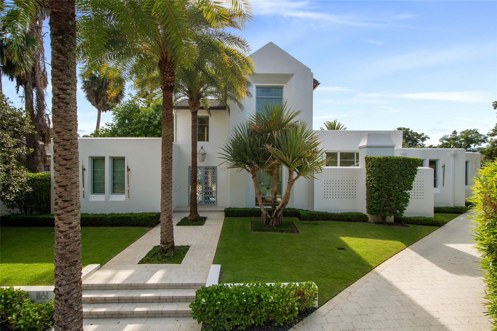 Conveniently situated near the Winter Park Country Club, this contemporary masterpiece, built by premier builder Z Properties, offers the ideal mix of style, comfort, and modern living. Completed in 2021, the residence has 4,181 square feet of thoughtfully designed living space, including four bedrooms each with a private ensuite bath and an additional powder room. A 412-square-foot casita with a wet bar and private entrance completes its functionality by providing extra flexibility, perfect for guests, extended family, workspace or workout area.
The interiors showcase timeless design with high ceilings, glass walls, and carefully curated finishes. The chef’s kitchen and butler’s pantry pair handcrafted cabinetry and stone surfaces with professional-grade appliances, flowing seamlessly into open living and dining spaces designed for both everyday living and entertaining.

Outdoors, a 65-foot lap pool anchors the private backyard retreat, complemented by a covered lanai, marine-grade summer kitchen, fireplace lounge, tree garden and lush landscaping. Solid block construction, advanced state-of-the-art home systems, and a climate-controlled two-car garage with an extended hidden driveway highlight the home’s privacy, quality, and convenience.

With a distinct European vibe under canopy trees and cobblestone streets in the desirable Valencia Terrace neighborhood, this home is just moments from Park Avenue’s boutiques, fine dining, Rollins College, the Farmers’ Market, and the Morse Museum. Zoned for top-rated Winter Park schools, it offers both luxury and practicality in one of Central Florida’s most sought-after communities.