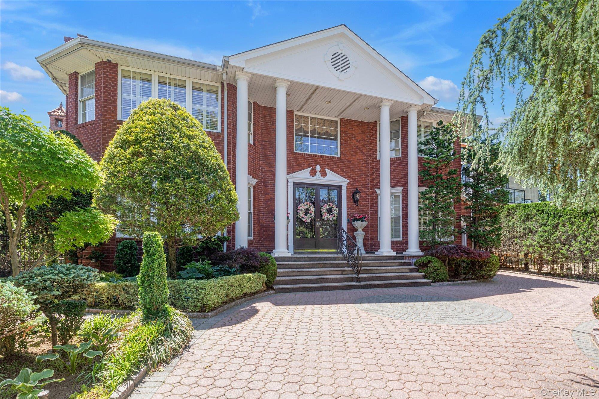 Unparalleled water views and timeless elegance - welcome to this Malba estate located ideally across from a sandy local beach and overlooking the iconic Whitestone Bridge. 
A large circular driveway and beautiful landscaping impress when driving up to this stately Whitestone residence. 
Step into the double height foyer that leads to an elegant formal living room, complete with a classic fireplace. The dining room provides an ideal setting for sophisticated entertaining, while the expansive gourmet kitchen is a chef's dream - featuring rich cherry cabinetry, gleaming granite countertops and top of the line appliances. The den leads out to the private fenced backyard. All the windows throughout have been customized with serene plantation shutters, and the building has been equipped with a complete water filtration system. 
Upstairs, you will find a grand landing with a panoramic window, and 4 generously appointed bedrooms plus two luxurious full baths. The fully finished lower level includes a summer kitchen, walk in closet, the laundry room, an office and full bathroom, offering versatile space for extended guests or casual gatherings.
Outdoors, indulge in resort-style living with a private, newly renovated heated saltwater pool surrounded by elegant pavers and a custom gazebo, making the yard perfect for relaxing and entertaining. The property features an attached one car garage as well as an additional detached garage large enough for 2 cars plus storage. 
This is a rare opportunity to own a refined water view retreat in one of Queens' most prestigious enclaves.