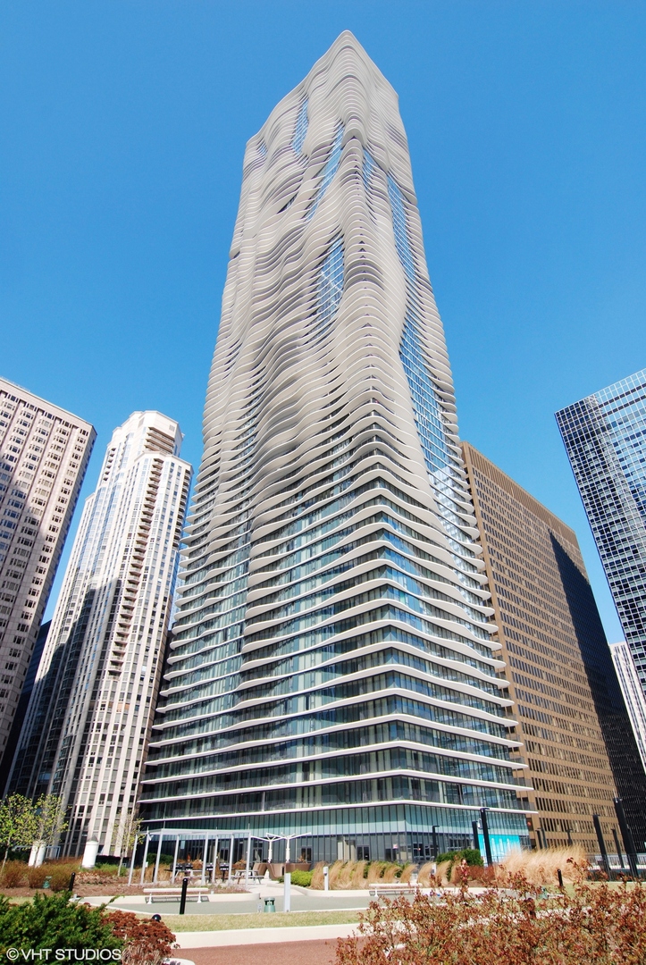 This southeast-facing corner 2-bedroom, 2-bathroom residence in the award-winning Aqua building offers expansive views of Lake Michigan, Navy Pier, the Chicago River, and the city skyline, all visible from two private balconies. The layout provides great natural light through floor-to-ceiling windows, and hardwood floors flow throughout the unit. The kitchen is equipped with Snaidero cabinetry, stainless steel appliances, and granite countertops, perfect for everyday cooking or entertaining. The primary bedroom includes a walk-in closet and a spacious ensuite bathroom featuring marble counters, Grohe and Moen fixtures, a double vanity, separate shower, and deep soaking tub. Residents enjoy access to the Shore Club, offering two full floors of indoor and outdoor recreational space, including Chicago's largest outdoor pool and amenity deck. Additional building amenities include indoor and outdoor pools, hot tubs, cabanas, a fitness center, Pilates studio, private theater, party room, business center, and direct access to the 4-acre Lake Shore East Park just outside your door.