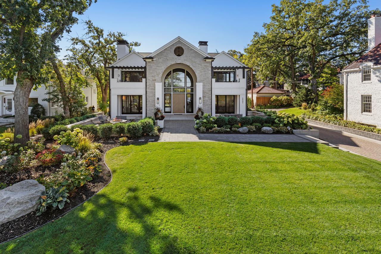 Stunning Lake Harriet masterpiece designed by Chris Light - executed to perfection showcasing unparalleled views of the lake, Bandshell and the Minneapolis skyline! Enjoy the world-class combination of timeless architecture and modern influences at every turn. The open flowing main-level features a living room with doors that open to the front patio overlooking the water;  gourmet kitchen with 2 large center islands, oversized sink, high-end appliances, wine fridge and expansive prep-pantry with additional appliances and formal + informal dining. Upper-level offering a large loft, laundry room and 3 bedrooms including the Primary Suite with spa-like bath (heated floors), 2 walk-in closets, fireplace and private deck featuring long water views!  The lower-level features a family room with bar + beverage fridge; amusement room and 2 guest bedrooms (one currently used as an exercise room). Additional features: Main-level office with custom built-ins and gas fireplace; “Smart Home” technology; large fenced-in backyard with putting green, pickleball court and rec space; private driveway. Attached heated 4-car garage with mudroom + detached heated 2-car garage, a rare find around the City Lakes! Perfectly sited to maximize privacy. See supplement for additional details.