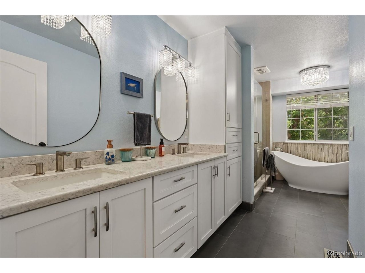 Rarely does a home of this caliber become available in sought-after Columbine Knolls South. Beautifully updated and meticulously remodeled, this exceptional two-story residence combines timeless elegance with modern comfort, offering an inviting floor plan designed for today's lifestyle.From the moment you arrive, you'll be captivated by the outstanding curb appeal featuring a welcoming covered front porch, updated pillars, newer windows, a newer stone-coated steel roof, and an oversized 3-car garage. Step inside the dramatic two-story foyer and discover new hardwood floors, new carpet throughout the main and upper levels, and an abundance of natural light.The heart of the home is the stunning remodeled kitchen, thoughtfully designed with crisp white cabinetry, slab quartz countertops, a large center island with undermount sink, oil-rubbed bronze hardware, and premium slate stainless steel appliances, including a 5-burner gas range with griddle and French-door refrigerator. Adjacent formal and casual dining spaces make entertaining effortless.A versatile main-floor bedroom with a full bath and French doors offers the perfect guest suite, private office, or study. The convenient main-floor laundry room adds everyday functionality.Upstairs, you'll find a spacious loft with hardwood flooring, three generously sized bedrooms, and a luxurious primary suite designed as a true retreat. Unwind in the sitting area with room for a lounge chair, then enjoy the beautifully remodeled spa-inspired five-piece bath featuring new cabinetry, vanities, fixtures, lighting, soaking tub, walk-in shower, luxury vinyl flooring, and a spacious walk-in closet.The finished basement provides additional living space, including a guest sleeping area and convenient half bath, ideal for visitors, recreation, or a home gym.