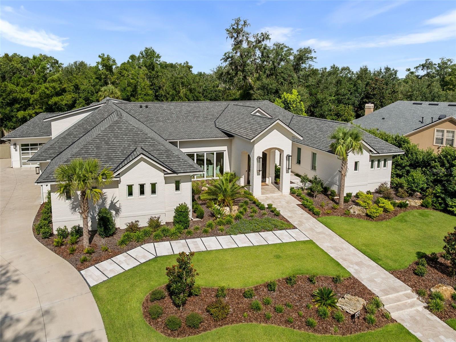 Under contract-accepting backup offers. Experience the pinnacle of luxury living in this stunning, custom-built masterpiece in the highly sought-after Branton Court of Haile Plantation. With an impressive 6,937 sq ft of heated/cooled living space and an additional 572 sq ft of climate-controlled unfinished space, this exceptional residence blends timeless design, modern innovation, and superior craftsmanship. Constructed with energy efficiency and longevity in mind, the home showcases ICF construction, classic brick exterior, and an extended-life roof, delivering both durability and refined curb appeal. Step through grand, custom-forged iron doors into an expansive open-concept layout, bathed in natural light from dramatic, oversized windows that frame views of the lush surroundings. This architectural gem offers 6 generously sized bedrooms, 4 luxurious en-suite full bathrooms, and 2 half baths, all thoughtfully designed with both comfort and elegance in mind. The home’s interior is enhanced by rich, wide-plank wood floors that flow gracefully throughout the main living areas, adding warmth, sophistication, and timeless elegance. This home also includes a rare and fully handicap-accessible private casita with its own spacious bedroom and spa-like en-suite bathroom—ideal for guests, in-laws, or live-in caretakers. The heart of the home is a gourmet chef’s kitchen, equipped with top-of-the-line Wolf and Sub-Zero appliances including an induction cooktop, double ovens, steam oven, warming drawer. Custom Busby cabinetry adds richness and functionality, while the stylish wet bar features a second dishwasher, ice maker, and wine refrigerator. For the ultimate entertaining experience, the residence is equipped with a premium built-in surround sound system, delivering high-fidelity audio throughout key living spaces. Tucked behind the cabinetry, discover a spacious walk-in hidden pantry, offering abundant storage, discreet organization, and a touch of luxury that blends seamlessly with the kitchen’s clean, elevated design. Unwind in the versatile bonus room, ideal for a media lounge, home gym, or playroom. Advanced home technology includes the Moen Flo Smart Water Monitor and Shutoff System, offering 24/7 leak detection and remote water control for ultimate peace of mind. Enjoy a quiet evening under the covered patio with a fully equipped summer kitchen. This expansive outdoor cooking area features a professional-grade grill, flat-top griddle, and generous counter space. Brand-new custom pool completed in May 2026. Every inch of this estate has been meticulously curated with premium finishes, designer details, and custom features that set it apart. This home offers an unparalleled lifestyle of comfort, sophistication, and lasting value. Don't miss the opportunity to own one of Haile Plantation’s most distinctive and desirable luxury homes.
