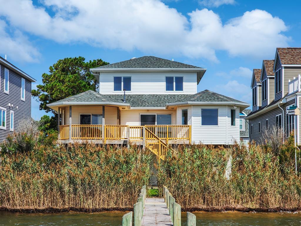 ***Chincoteague Bayside Dream*** This beautiful bayfront home recently had several improvements done. The main living level has all new LVP flooring, new LED lights, new ceiling fans, and a new bathroom vanity. Other improvements include, new roof, new 2-zone HVAC, and a new back deck. The main level features front and rear decks, an open floor plan, with waterfront dining area, a primary suite that walks out to a waterfront deck, a walk-in closet, and a private bathroom as well. There is another bedroom and a full bathroom on this level. The top floor features 2 waterside bedrooms and a third full bathroom.  This home is a dream with 2 spacious garages, center storage room, private pier and sooo much with all of the community amenities. Don't miss out on this one.